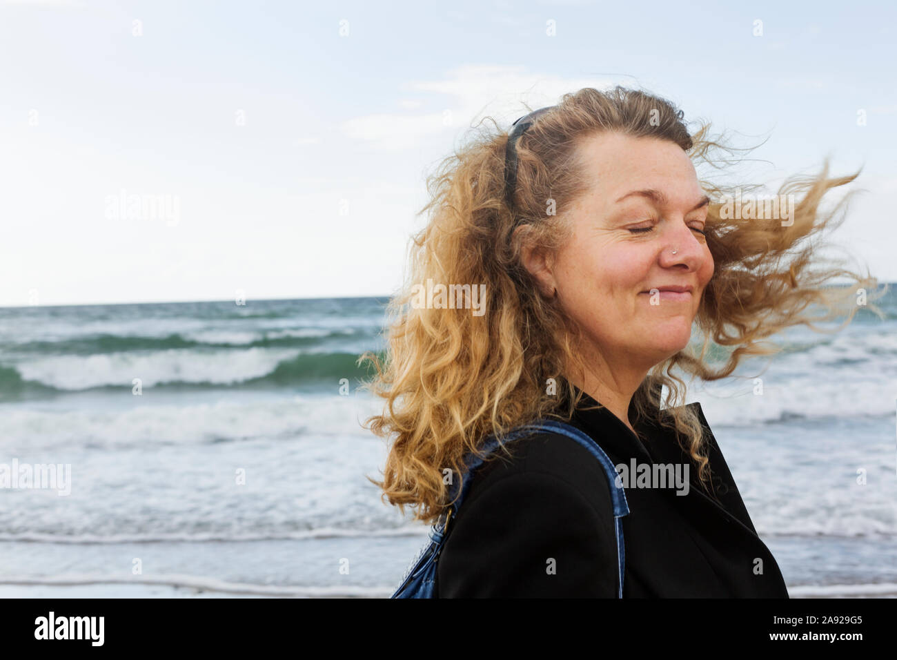 Eine Frau am Meer mit Haar im Wind bewegen Stockfoto