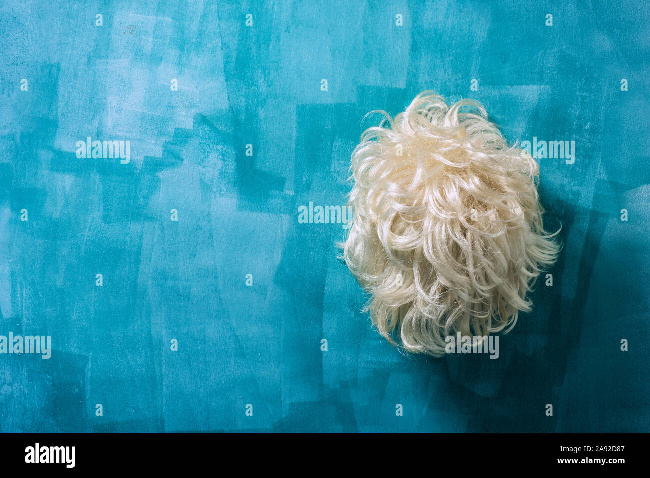 Blonde Perücke an der Wand aufhängen. Stockfoto