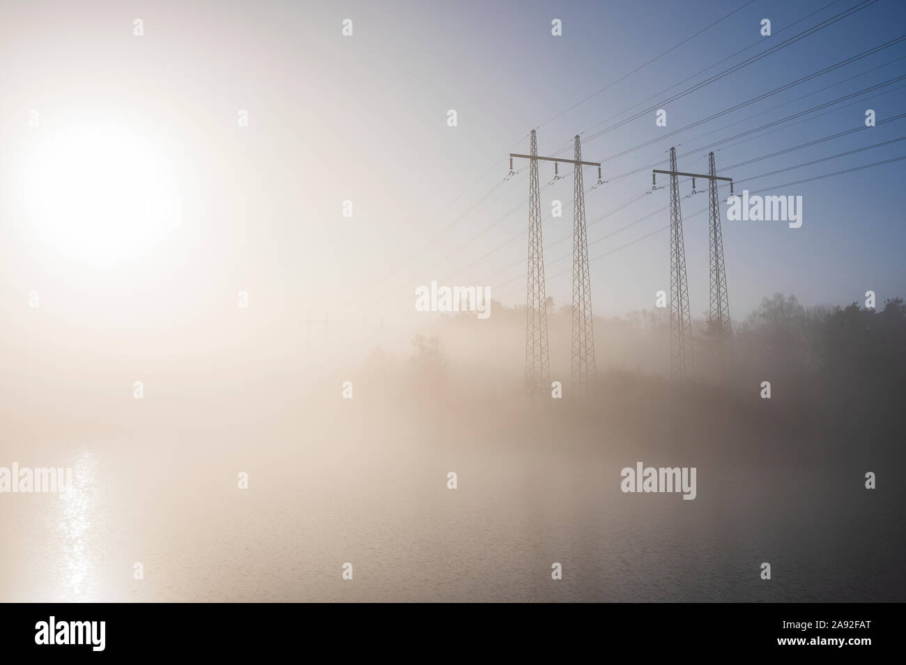 Strommasten im Nebel Stockfoto