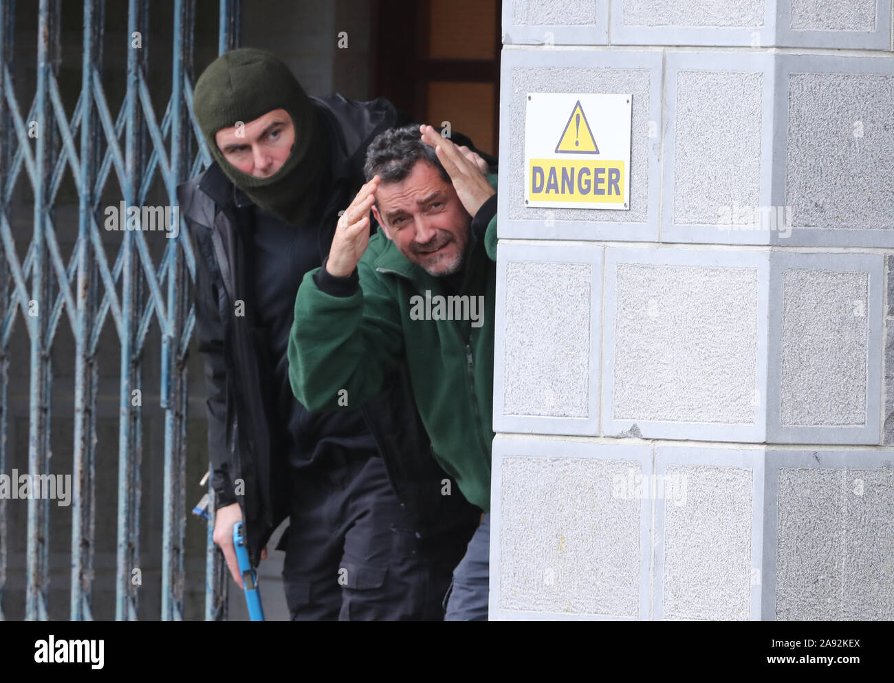 Ein Schauspieler in der Rolle eines Geisel (rechts) und ein Mitglied der Sicherheitsdienste in die Rolle der Geiselnehmer erscheinen während einer Agentur notfallübung am Newtownfane Pumpstation, Co Louth, Irland. Stockfoto