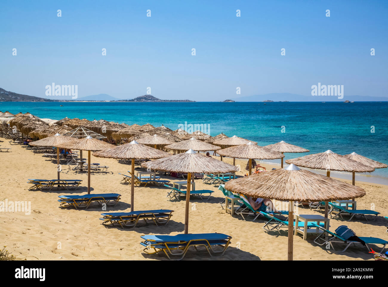 Resort mit Stühlen und Schutz am Strand Plaka am Mittelmeer; Naxos Insel, Kykladen, Griechenland Stockfoto