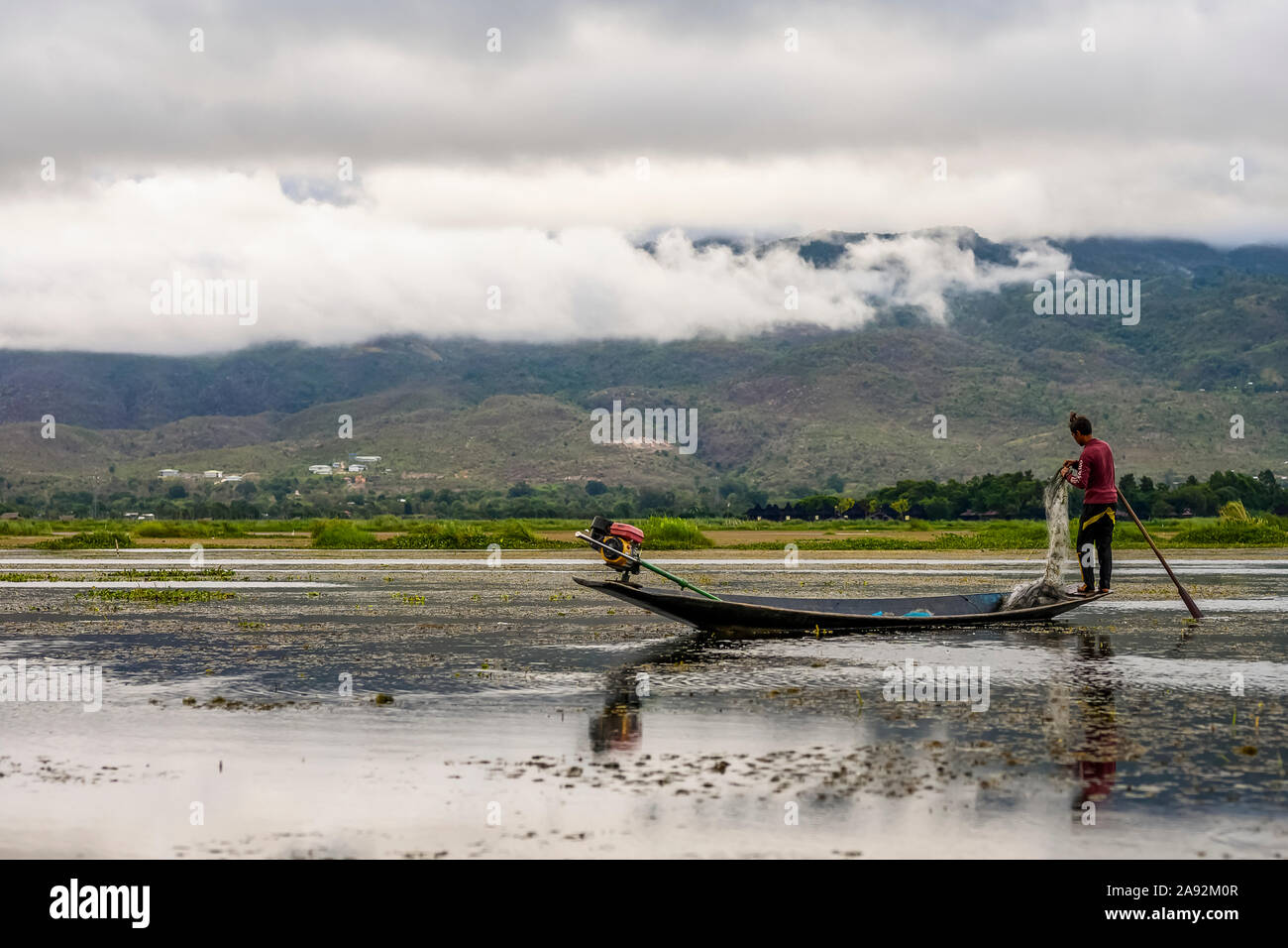 Fischer stehen am Rand des Bootes mit Netz und paddeln in Inle Lake; Yawngshwe, Shan State, Myanmar Stockfoto