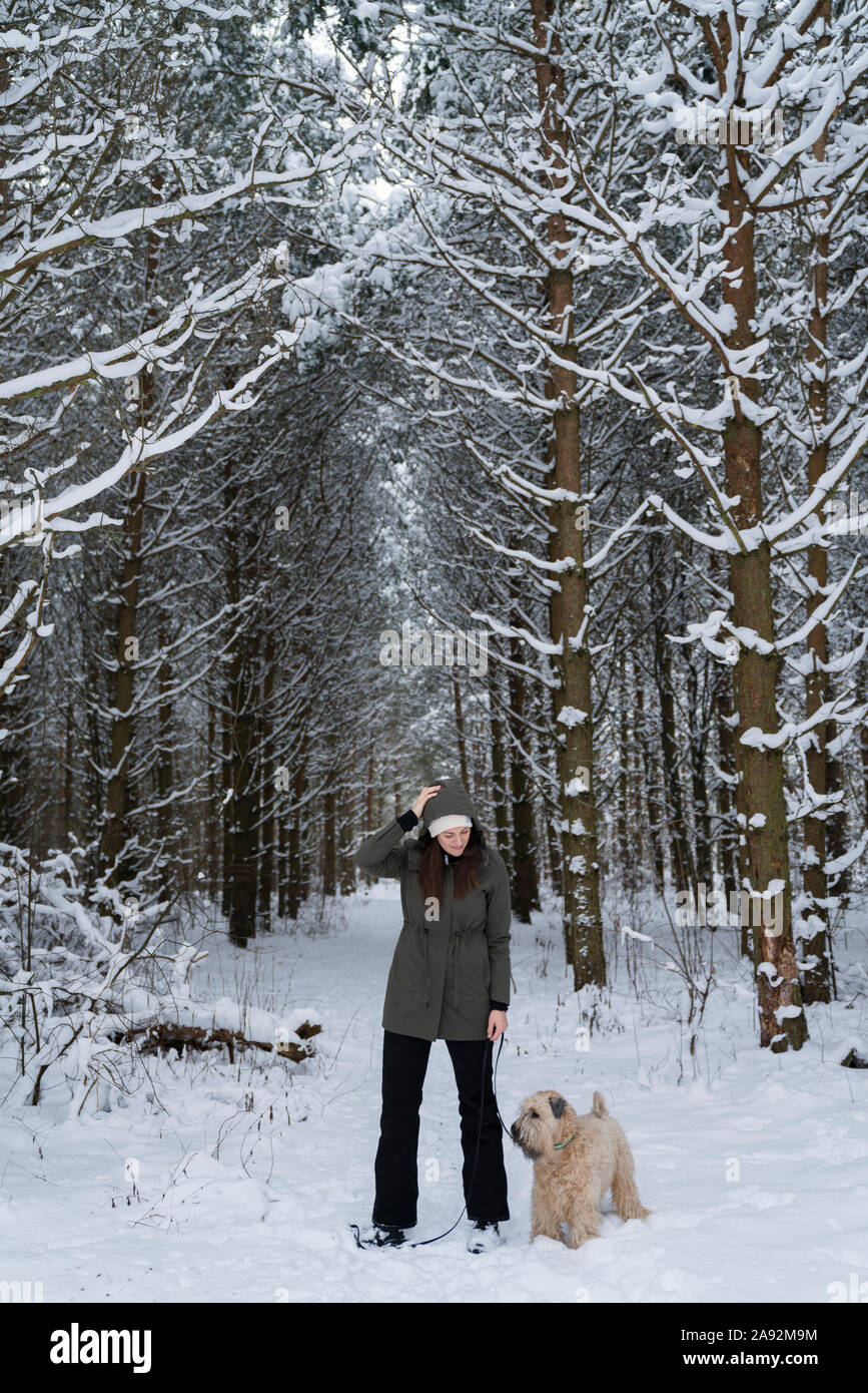 Frau mit Hund im Winter Wald Stockfoto