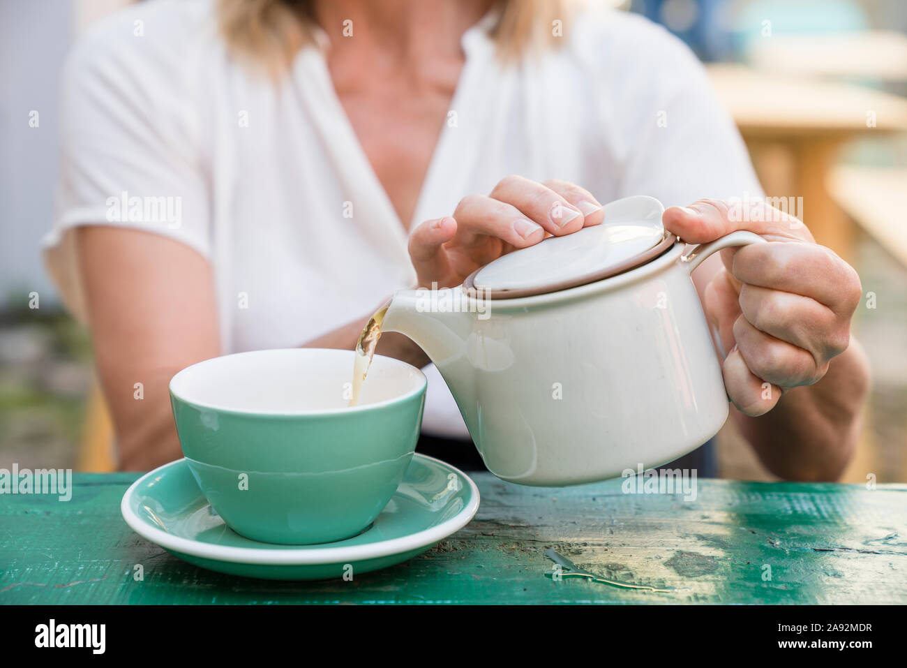 Frau gießen Tee in Tasse Stockfoto