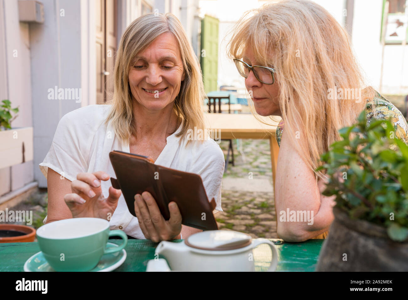Weibliche Freunde im Café im Freien Stockfoto