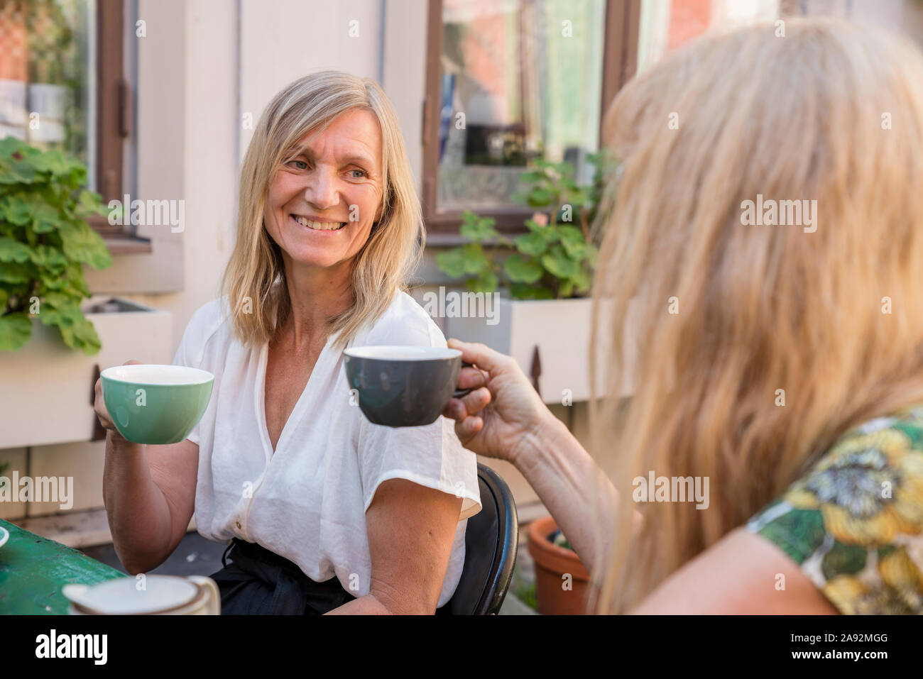 Weibliche Freunde Kaffee im Café im Freien Stockfoto
