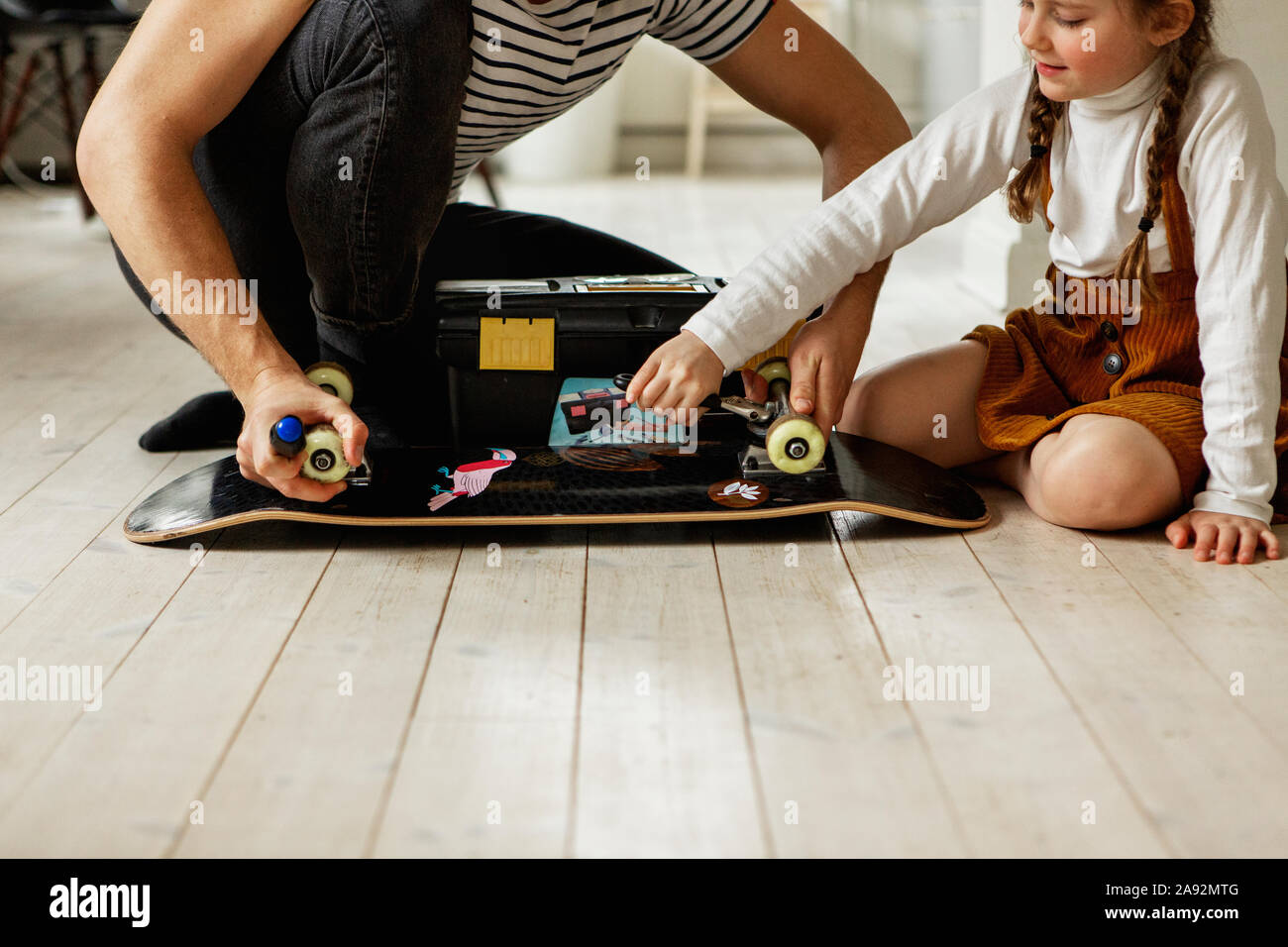 Vater und Tochter skateboard Rädern prüfen. Stockfoto