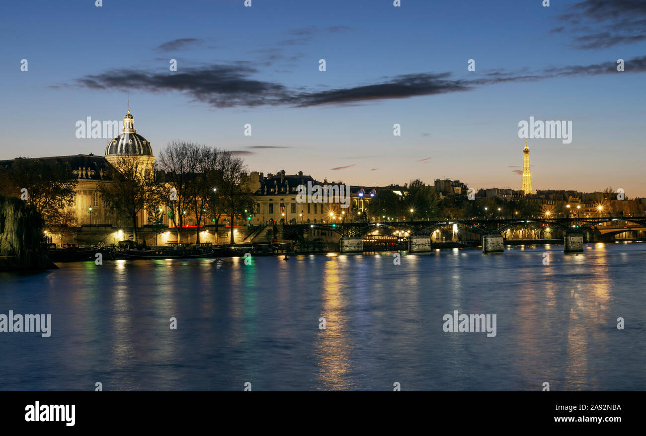 Paris, Frankreich, 05. November 2019: Bank der Seine in Paris am Abend. Unter den Gebäuden gibt es Kuppel des Französischen Institut und dem Eiffel Turm gelegen. Stockfoto