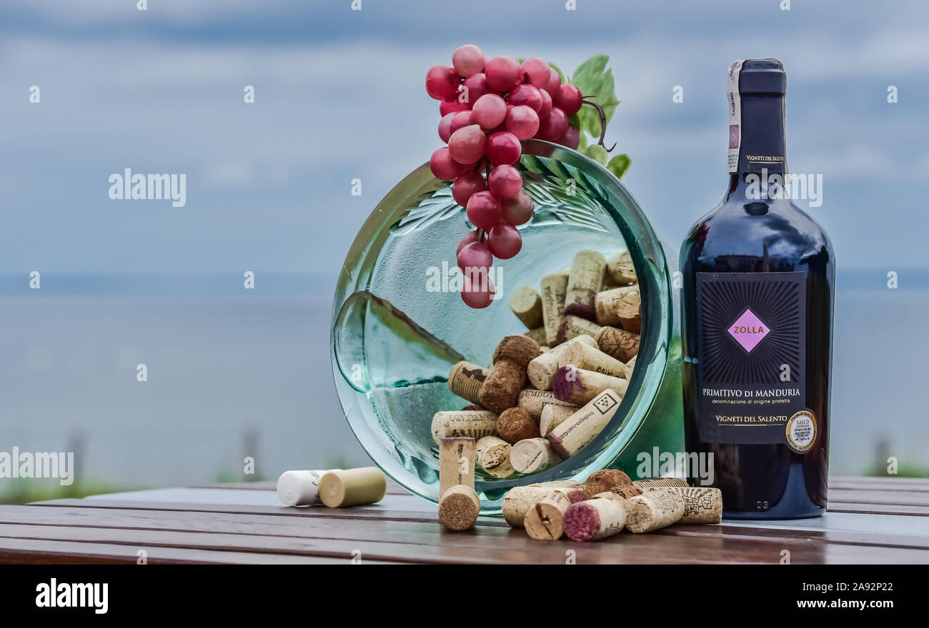 Flasche Rotwein mit Schüssel von Korken und Trauben Stockfoto