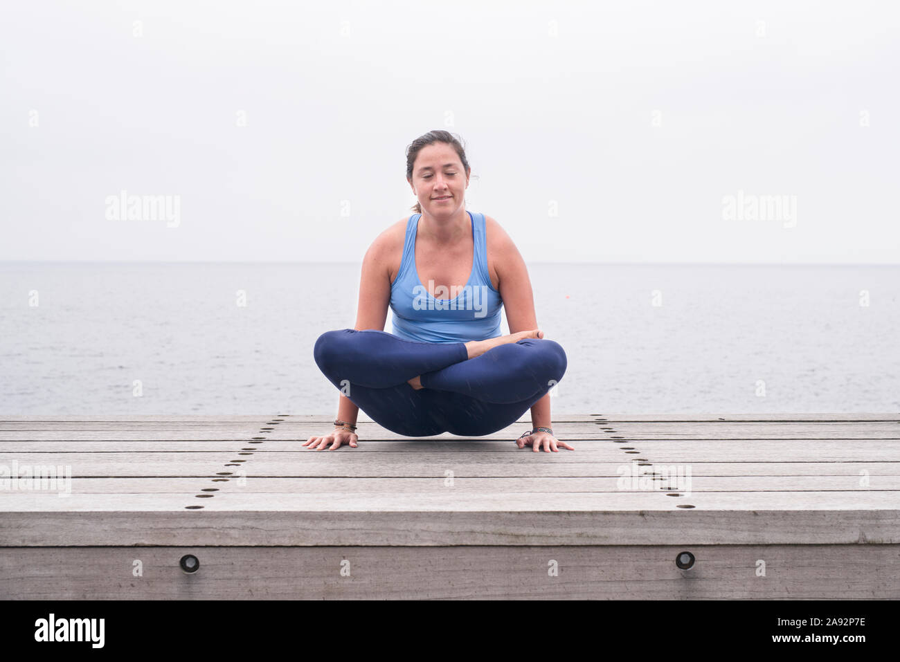 Frau Yoga am Meer Stockfoto