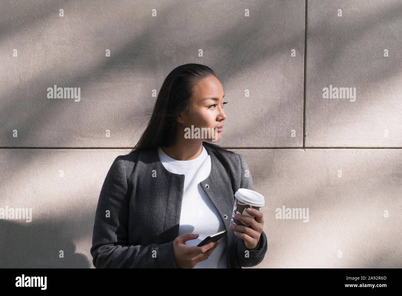 Junge Frau mit Einweg Becher Stockfoto