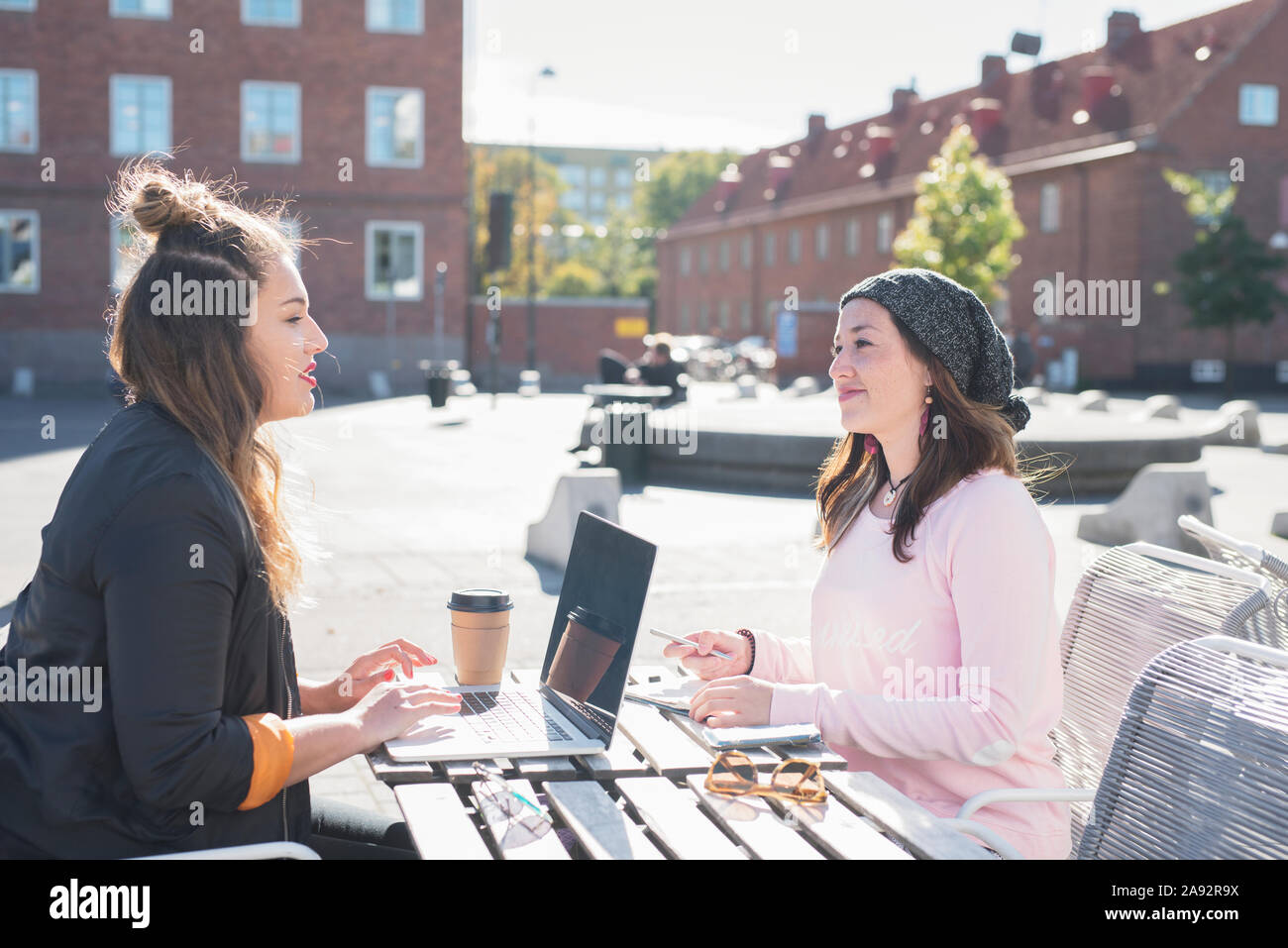 Junge Frauen im Café draußen sitzen Stockfoto