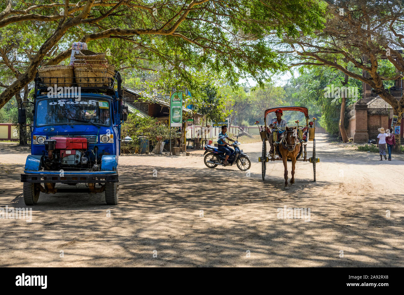 Verschiedene Verkehrsträger auf einer Straße mit LKW, Motorrad, Pferd und Kutsche; Bagan, Mandalay Region, Myanmar Stockfoto