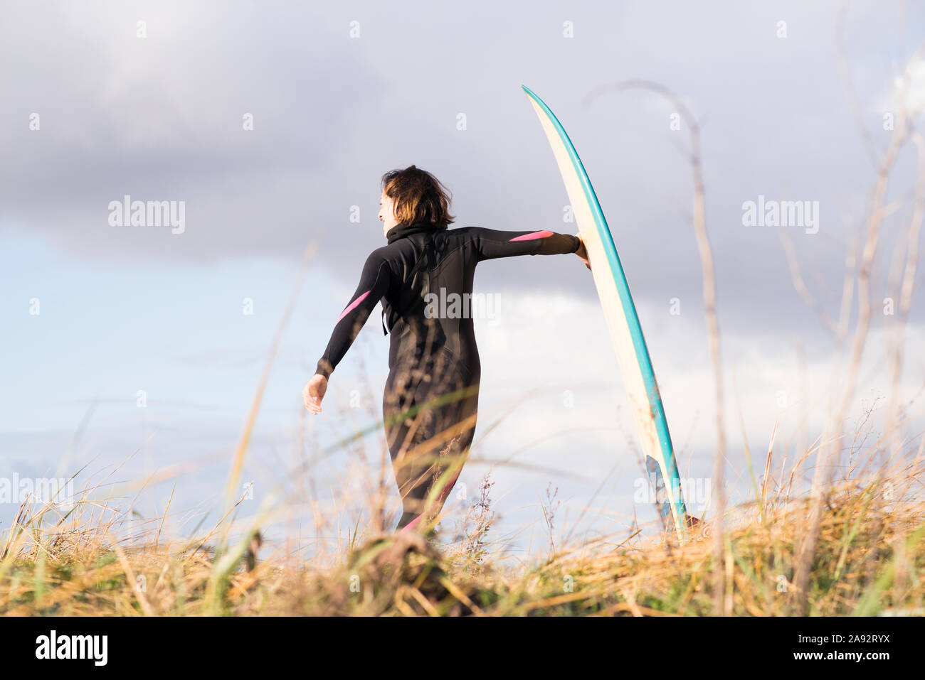 Weibliche Surfer mit Surfbrett Stockfoto