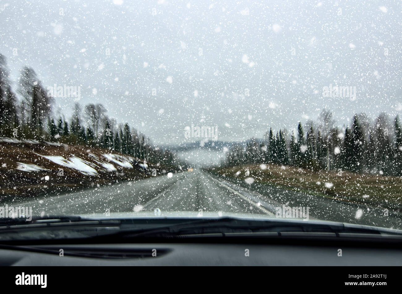 Fahrzeugsicherheit im Winter. Auto fahren in gefährlichen Wetter mit schlechter Sicht bei Schneefall und Nebel auf der Autobahn, Konzept für die Sicherheit in Stockfoto