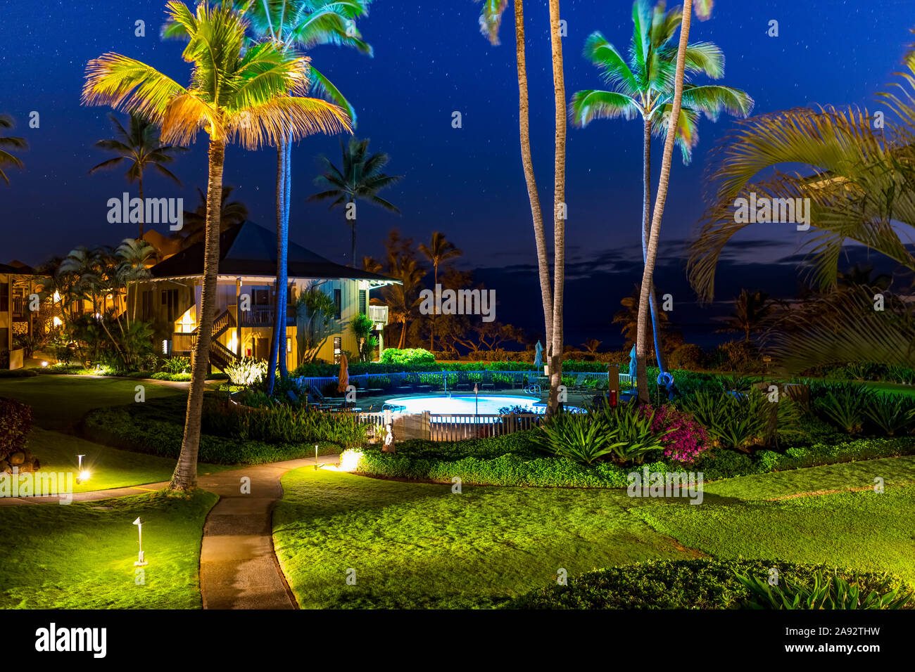 Haus mit Pool und Palmen in der Nacht beleuchtet; Kauai, Hawaii, Vereinigte Staaten von Amerika Stockfoto