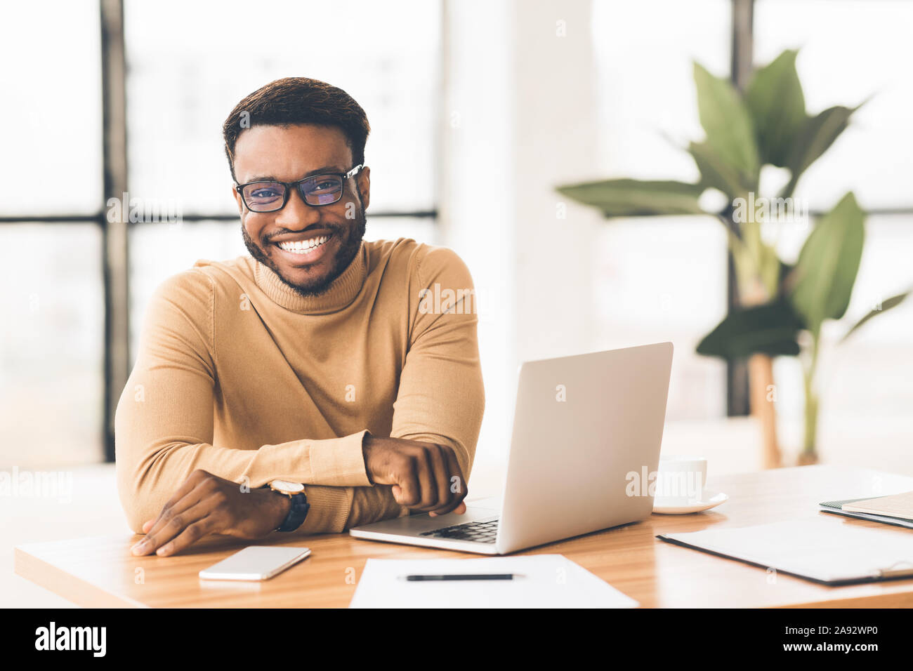 Portrait von stattlichen Geschäftsmann an Kamera im Büro suchen Stockfoto