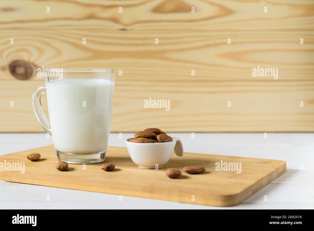 Mandeln und Glas mit Mandelmilch auf hölzernen Hintergrund Stockfoto
