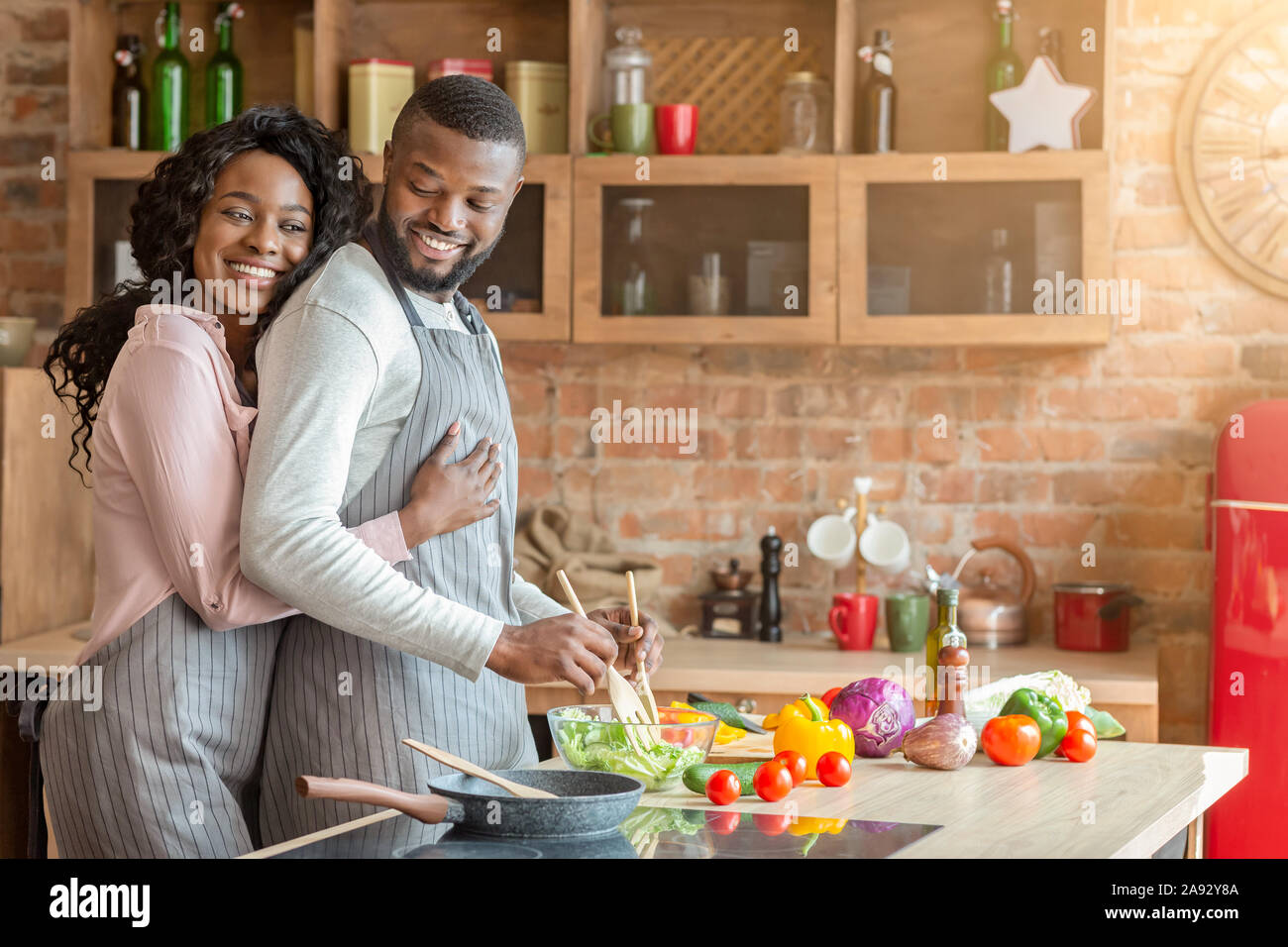 Dankbar Frau ihrem Mann umarmt von hinten in der Küche Stockfoto