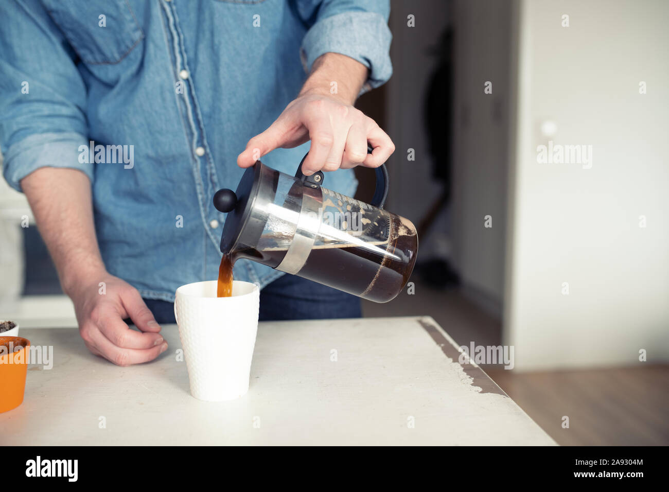 Man gießt Kaffee aus französischen Presse Stockfoto