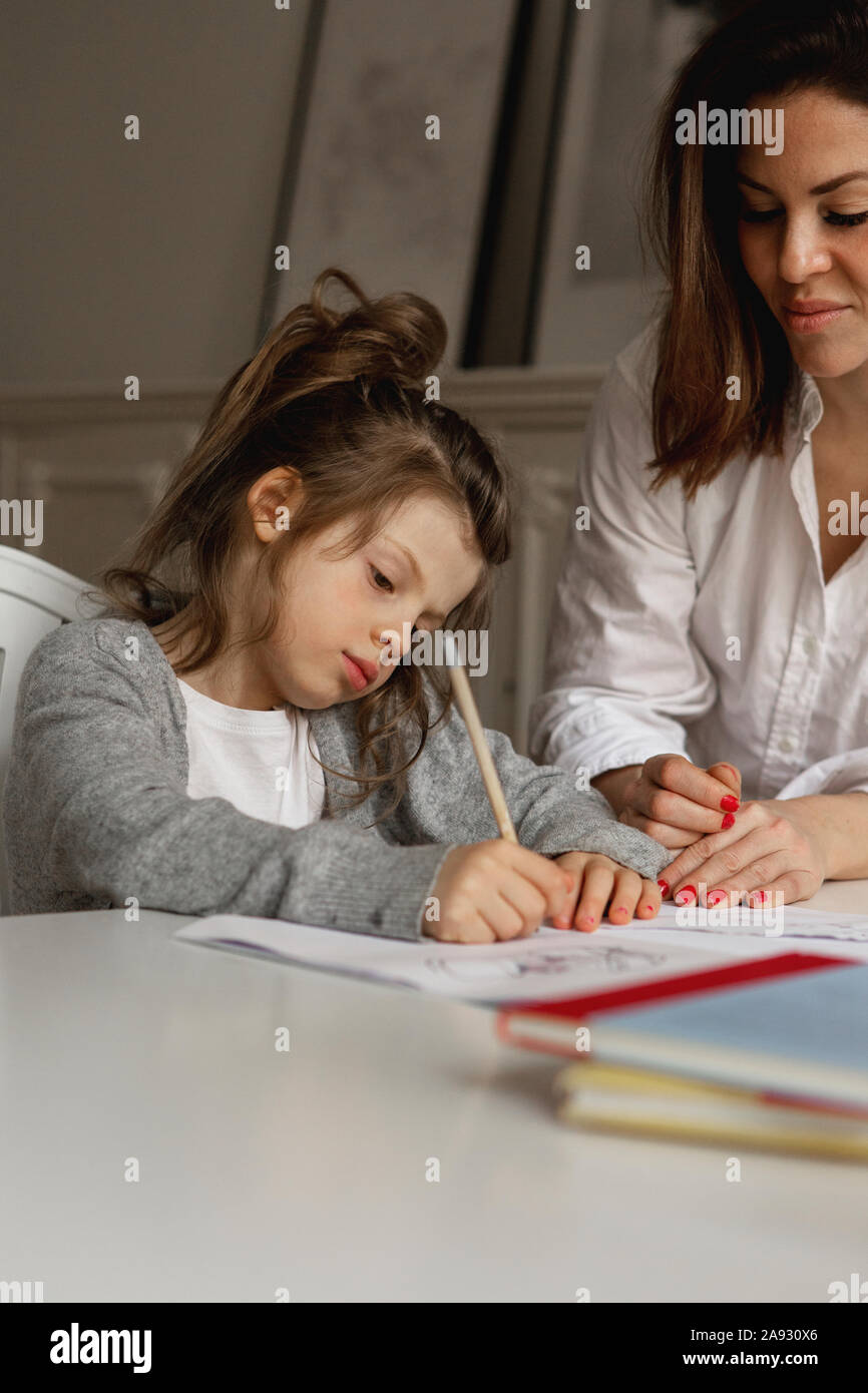 Mutter Tochter helfen bei den Hausaufgaben Stockfoto