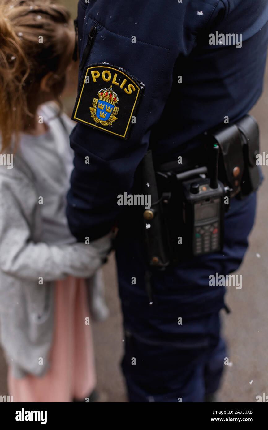 Polizei Frau mit Mädchen Hand Stockfoto