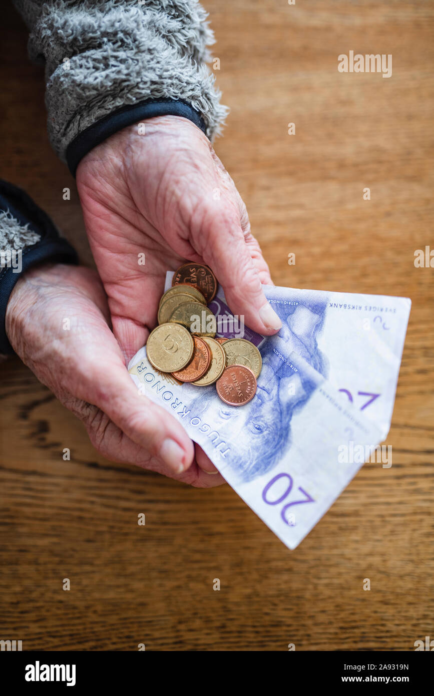 Hände, die Euro-Banknoten und -Münzen Stockfoto