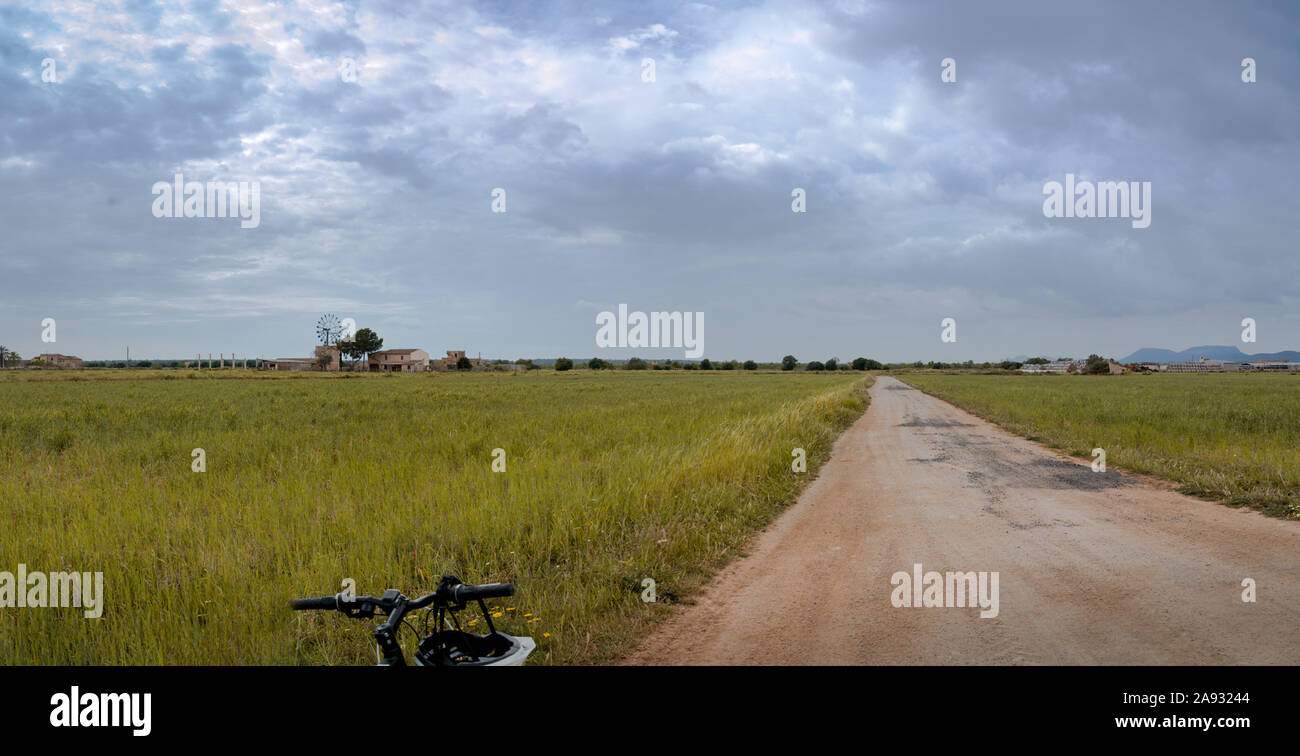 Typisch mallorquinische Landschaft während einer stürmischen Tag, in dem Sie den Lenker eines Fahrrades mit einem Helm zu sehen Stockfoto