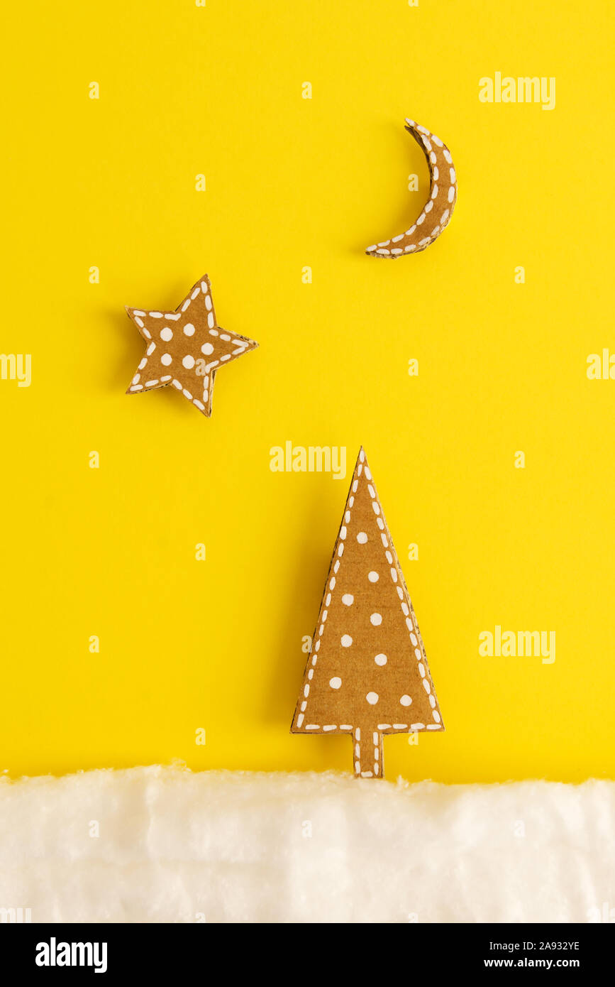 Weihnachtskarte mit ein Bild von einem Weihnachtsbaum aus Pappe auf gelbem Hintergrund Stockfoto