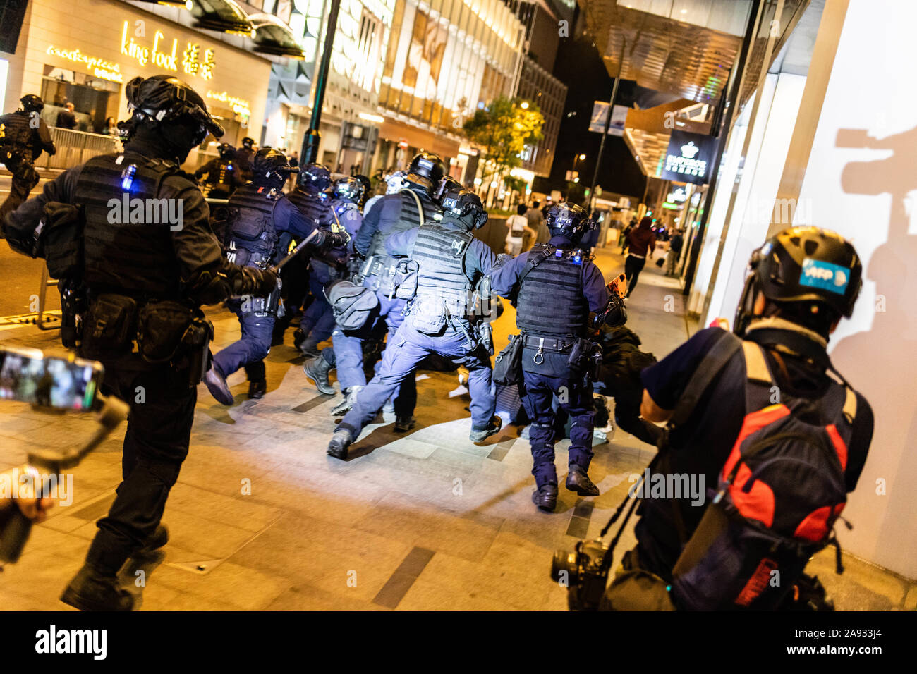 Die Bereitschaftspolizei gegen eine Demonstrantin auf den Boden während der Demonstration. Eingabe der 5. Monat der Unruhen, Demonstranten weiter Straßen und Züge zu blockieren, drücken für einen Generalstreik. Die Demonstranten skandierten Parolen und fuhr fort zu Fragen für die fünf Forderungen erfüllt werden. Die Demonstranten zu Zusammenstößen zwischen Polizei und wurden mit Tränengas schlagen, bis mehrere schließlich verhaftet wurden. Stockfoto