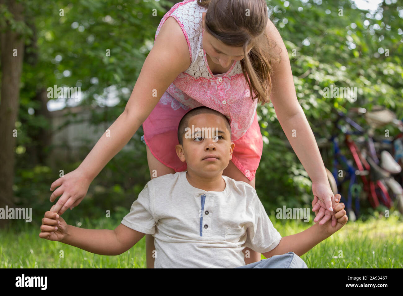 Hispanischer Junge mit Autismus, der draußen mit seiner Schwester spielt Stockfoto