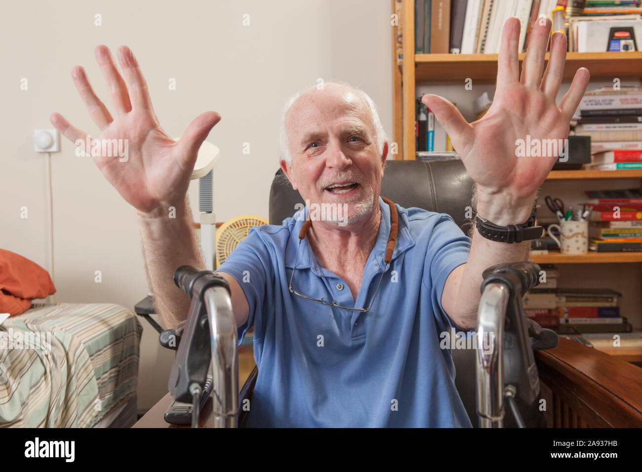 Mann mit Ataxia mit seinem Wanderer und gestikulierenden in seinem Schlafzimmer Stockfoto