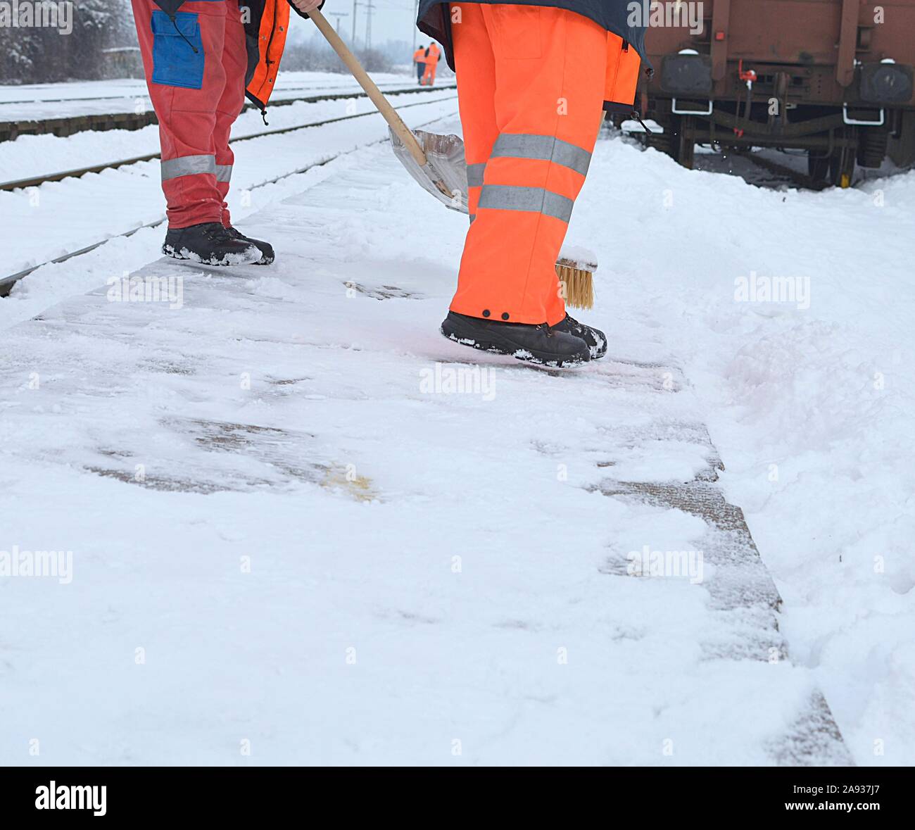 Arbeitnehmer Schnee auf dem Bahnhof in Arbeitskleidung Stockfoto