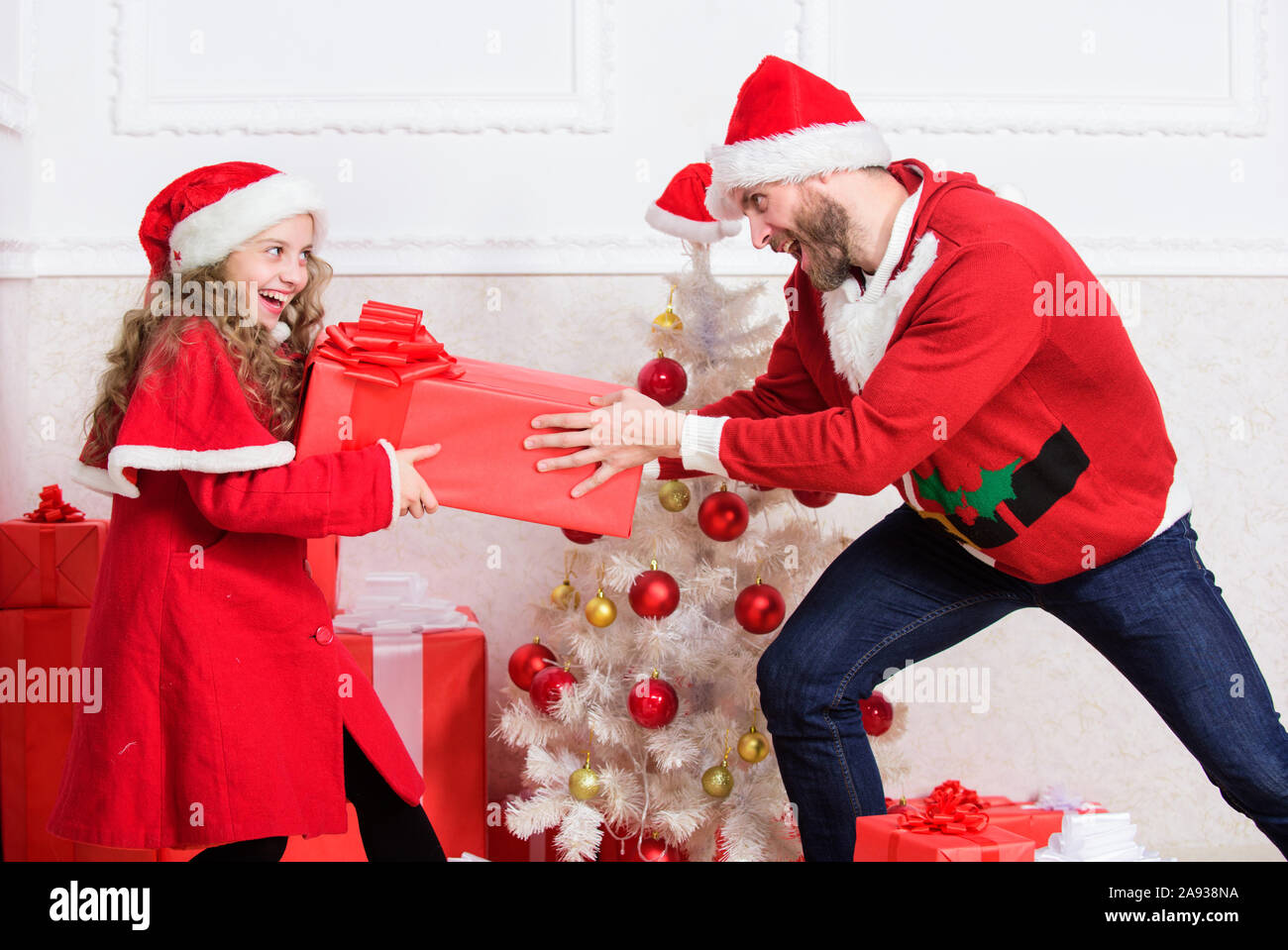 Kid niedliche Mädchen spielen mit Vater in der Nähe der Weihnachtsbaum. Verspielte Tochter und Vater Weihnachten feiern. Winter Aktivität und Spaß. Kind vortäuschen kämpfen Stockfoto