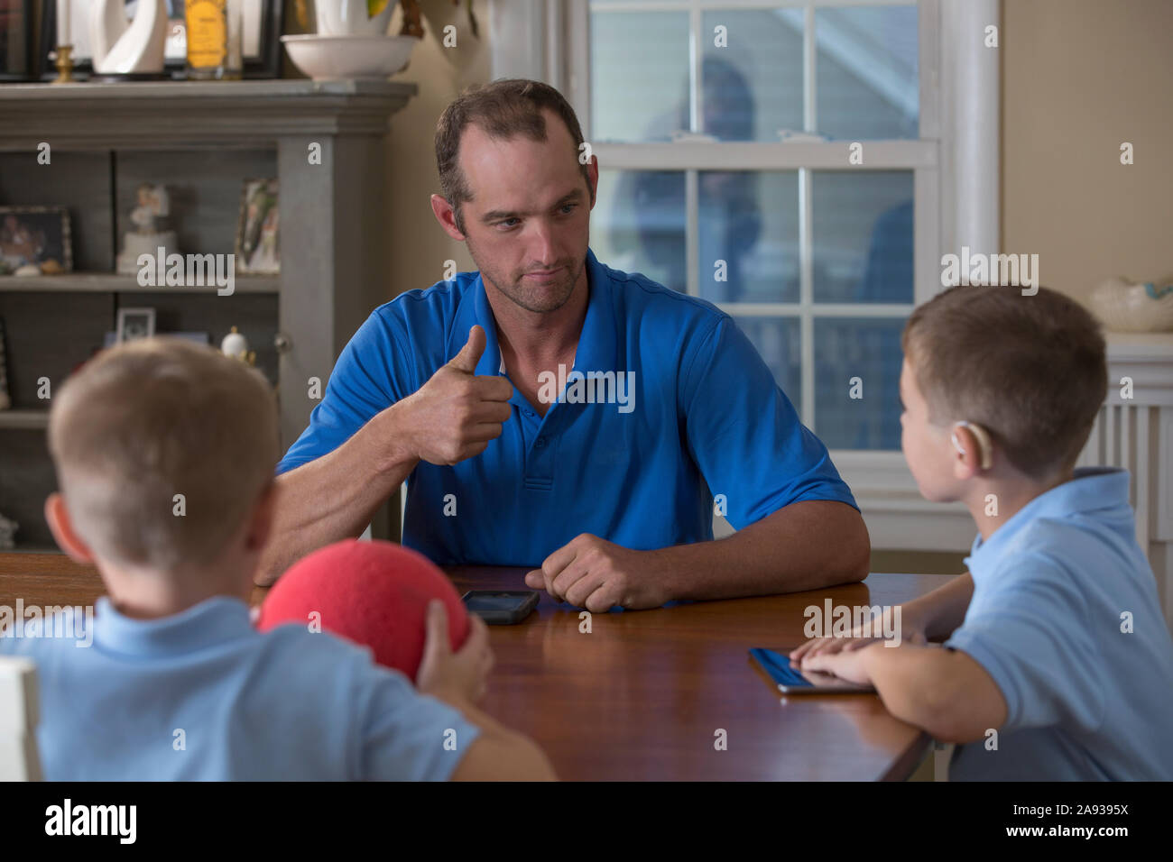 Vater kommuniziert mit Söhnen in American Sign Language über 'Cool Und gute Arbeit zu Hause Stockfoto