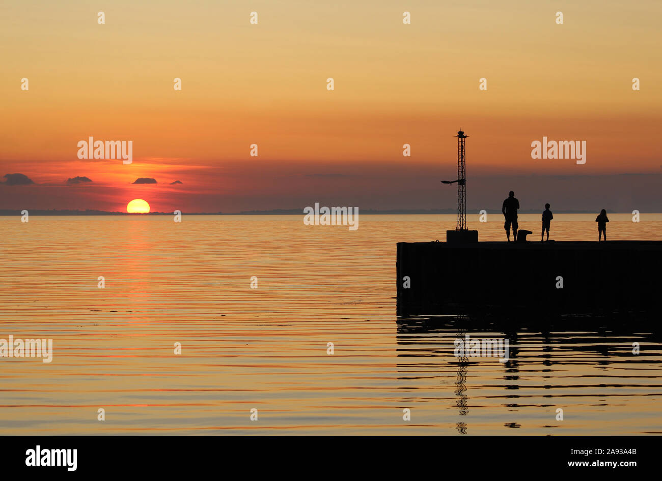 BAGENKOP, Dänemark, 17. JULI 2019: Familie Uhren schöne bunte Sonnenuntergang von der Mole in Bagenkop auf Langeland. Bagenkop ist ein beliebter Sommer holida Stockfoto