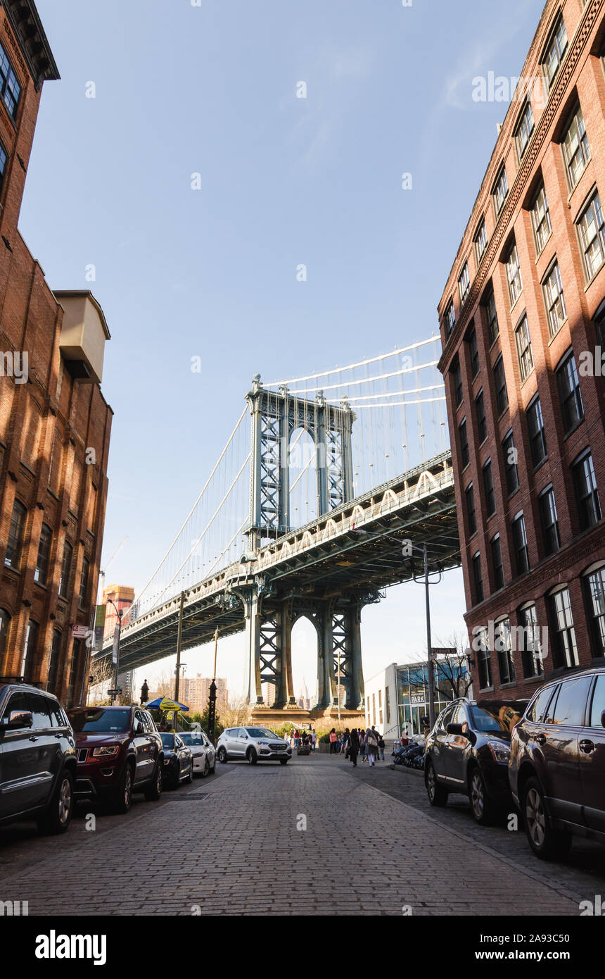 Vertikale iconic Blick auf Manhattan Bridge und berühmten Gasse mit Autos und Backstein Gebäude umgeben von dumbo an einem sonnigen Tag. Stockfoto