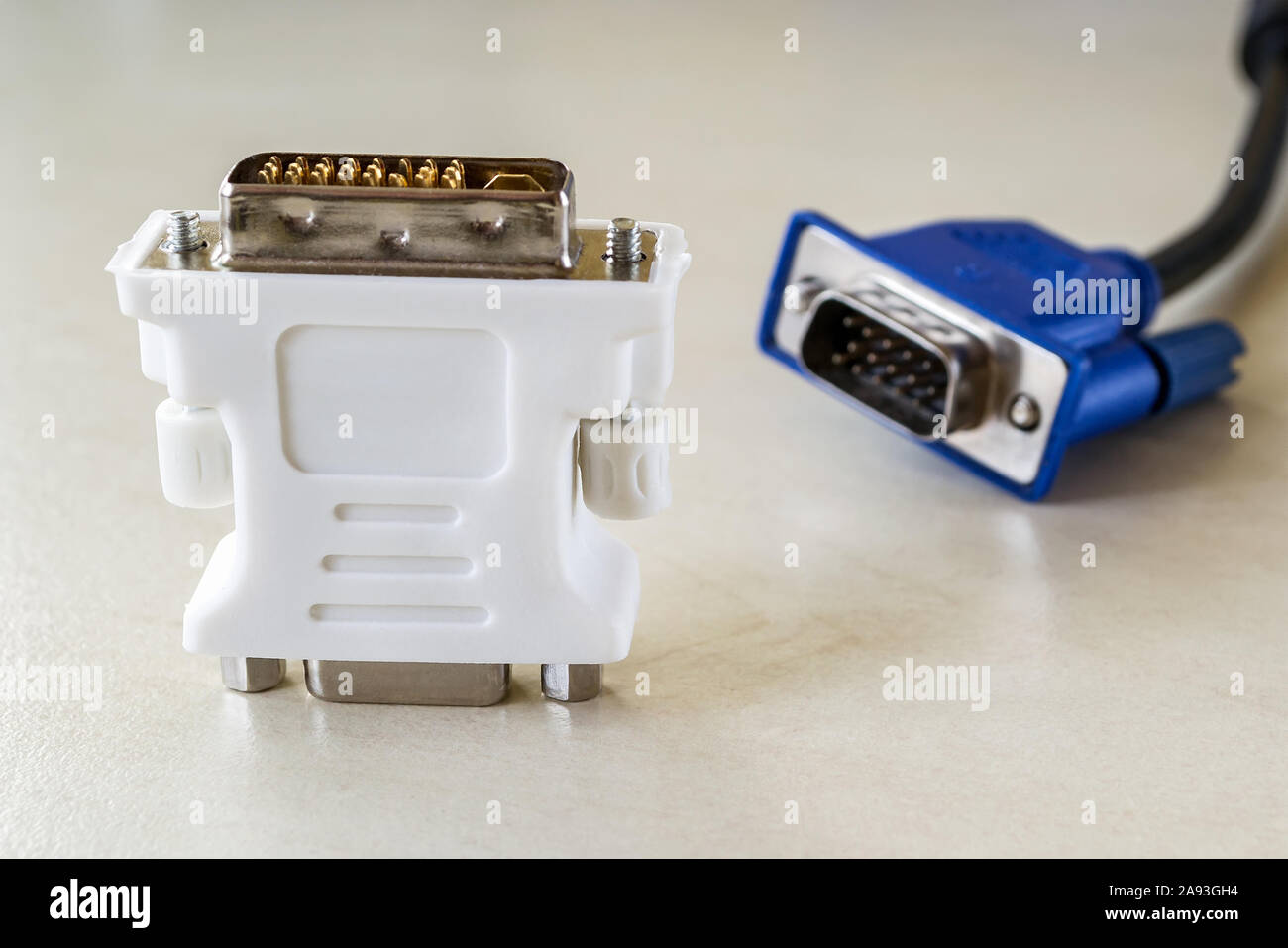 Weiß Adapter zum Anschluss von DVI-D und VGA und blauen Monitor Kabel hinter sich. Anschluss von Computer Geräte mit Steckern der verschiedenen Arten. Close-up. Stockfoto