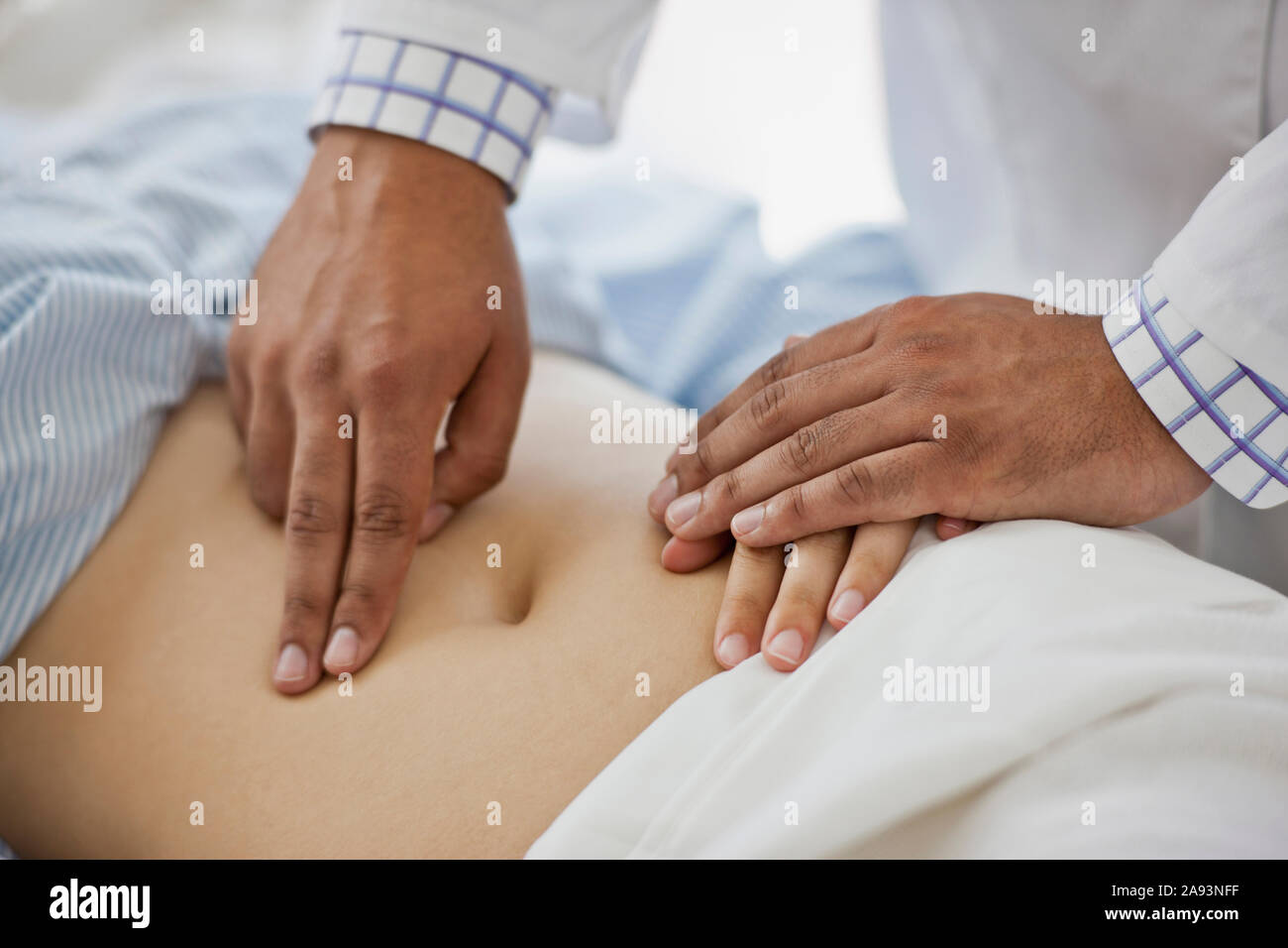 Hände eines Arztes, der den Bauch einer Patientin untersucht Stockfoto