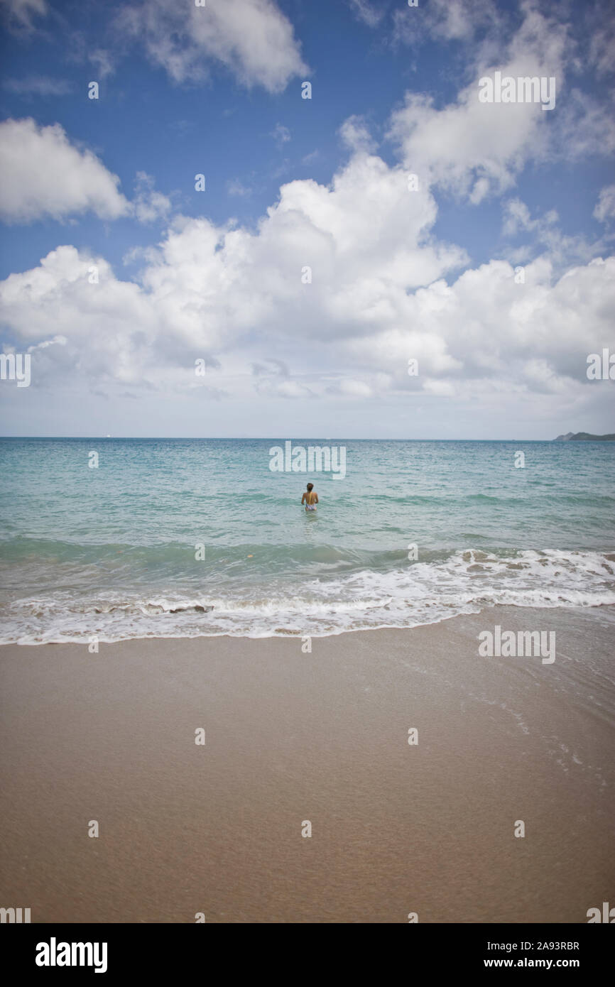 Frau zu Fuß ins Meer am Strand. Stockfoto