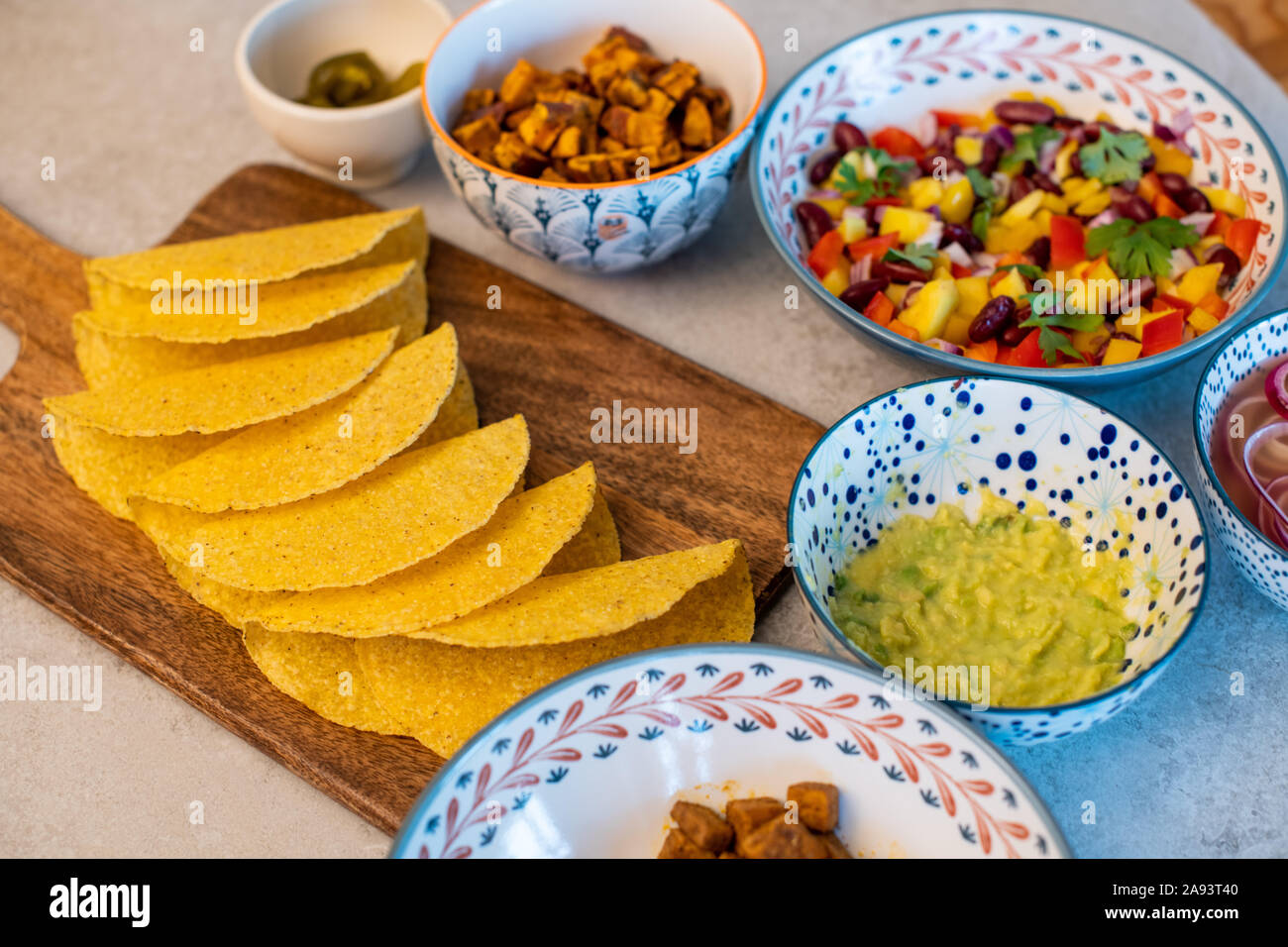 Vegan hausgemachte leckere Tacos mit Süßkartoffeln, Tofu, Avocado Sauce, Jalapeno und Mango Salsa Stockfoto