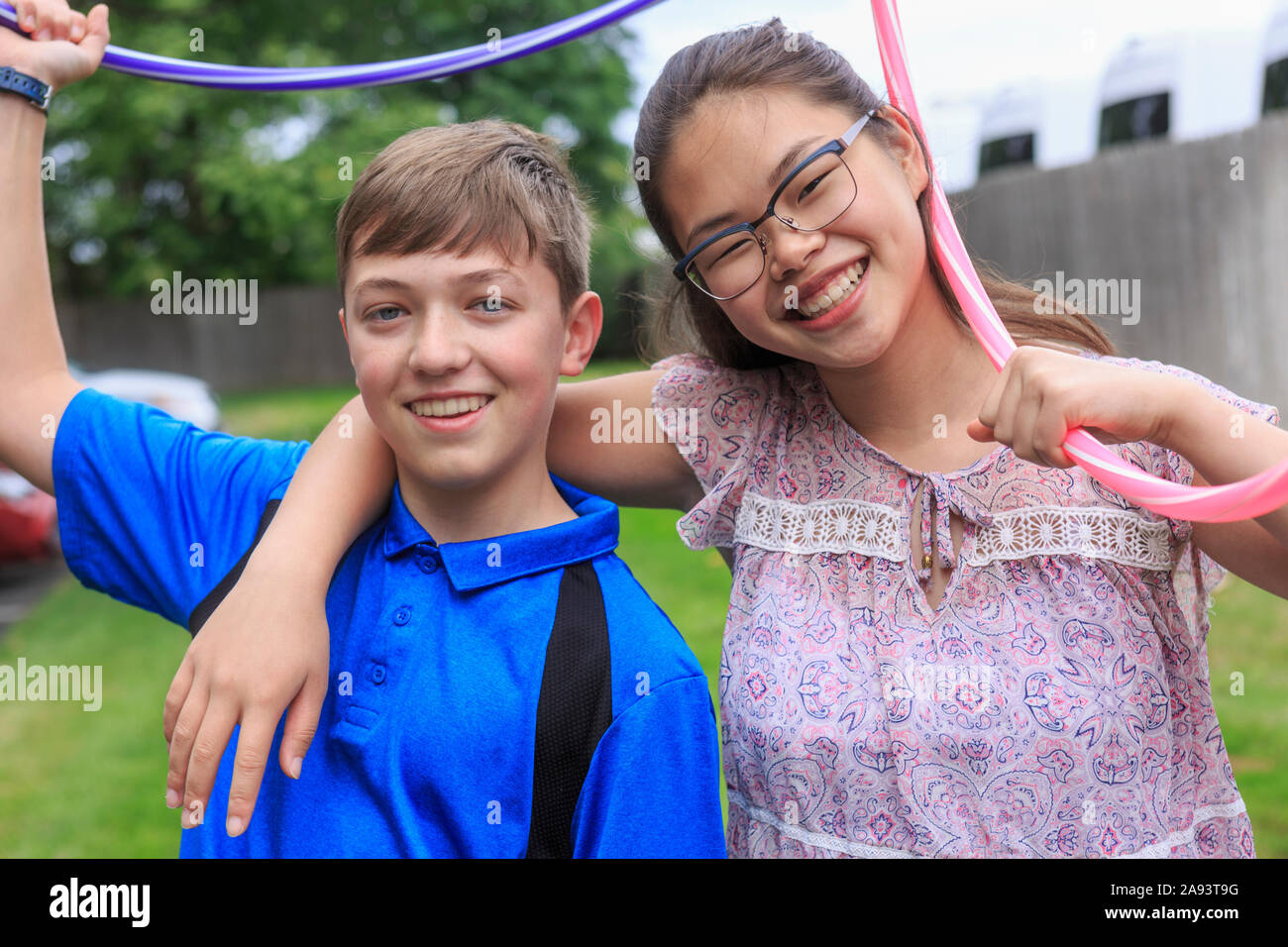 Teens Mädchen, die hat Lernen Behinderung spielen Hula Hoops mit Ihr Bruder Stockfoto