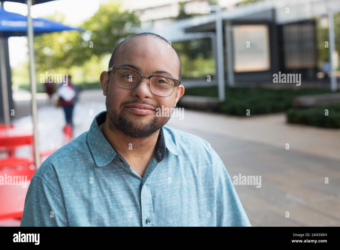 Afroamerikanischer Mann, der DownSyndrom hat, der auf dem Bürgersteig steht cafÃ