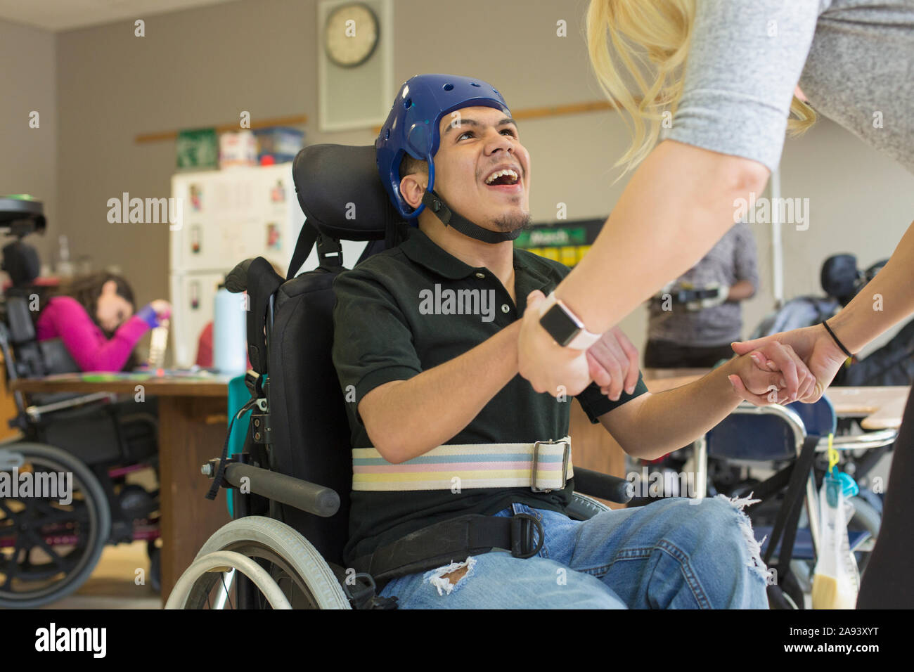 Junge mit spastischen viereckigen zerebralen Lähmung mit seinem Helm Und Gurt Stockfoto