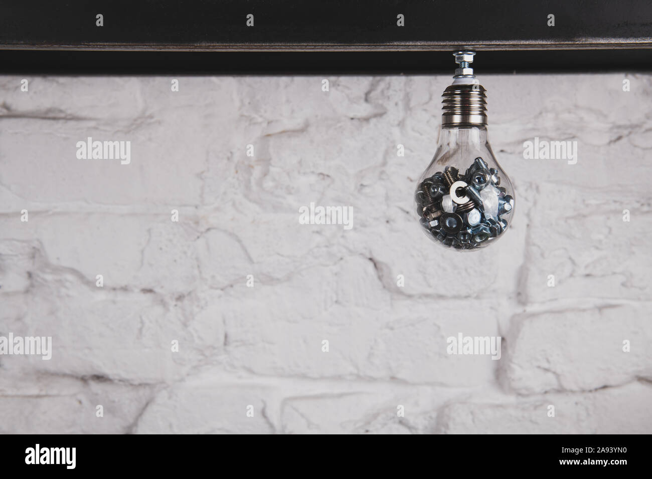 Lampe mit Schrauben und Muttern gegen die weiße Wand. Handgefertigte ungewöhnliche Objekt. Ideen sammeln Konzept Foto. Kreative Person Konzept. Kopieren Sie Platz. Stockfoto