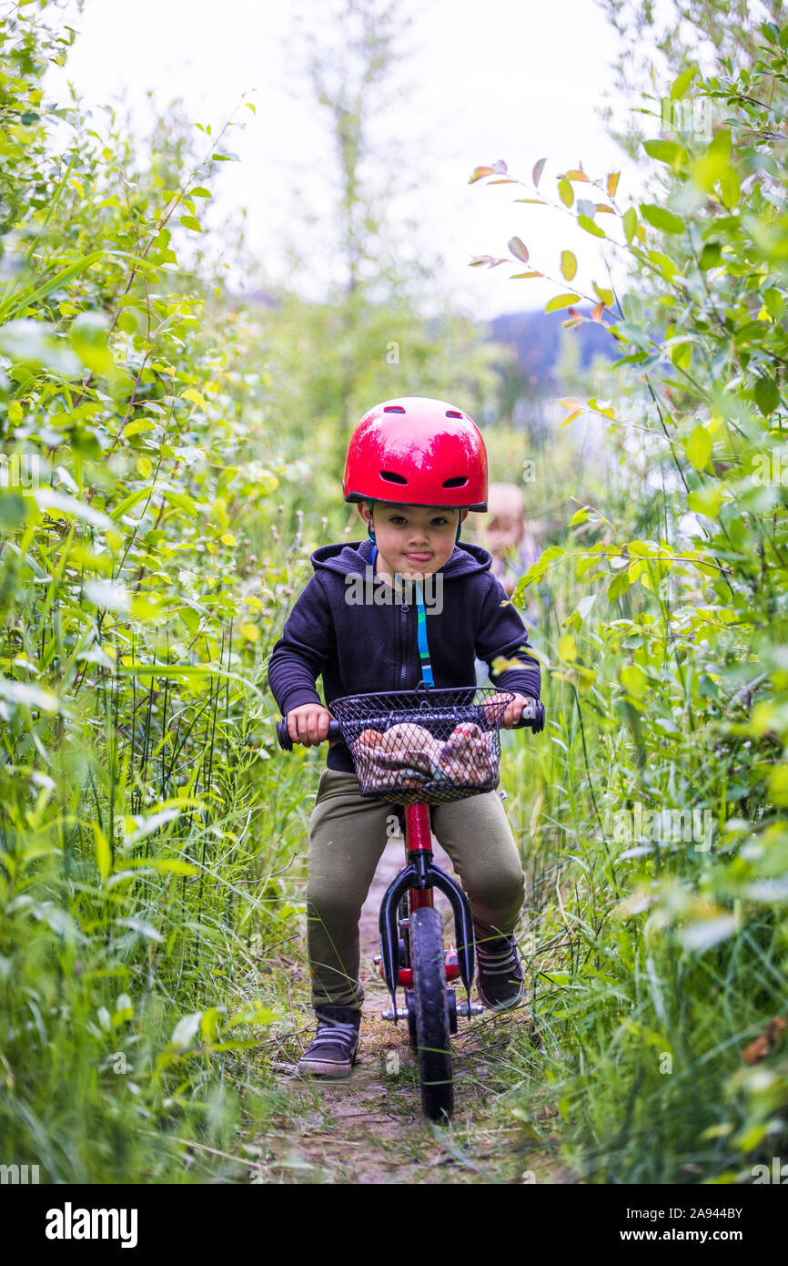 Kleinkind junge Reiter Balance mit dem Fahrrad durch den Wald. Stockfoto