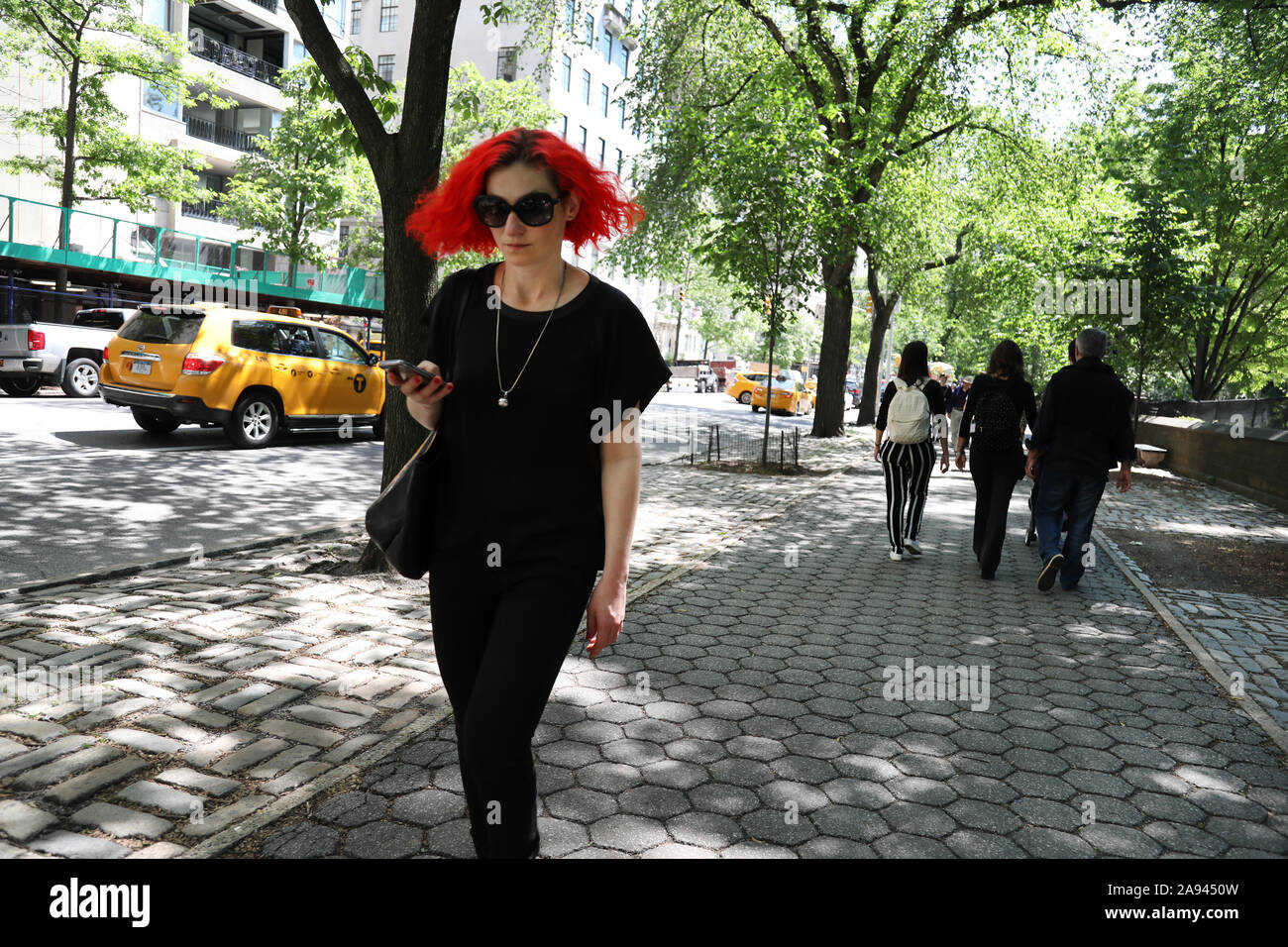 Junge Frau mit leuchtend roten Haaren auf der 5th Avenue, zum Central Park, New York Stockfoto