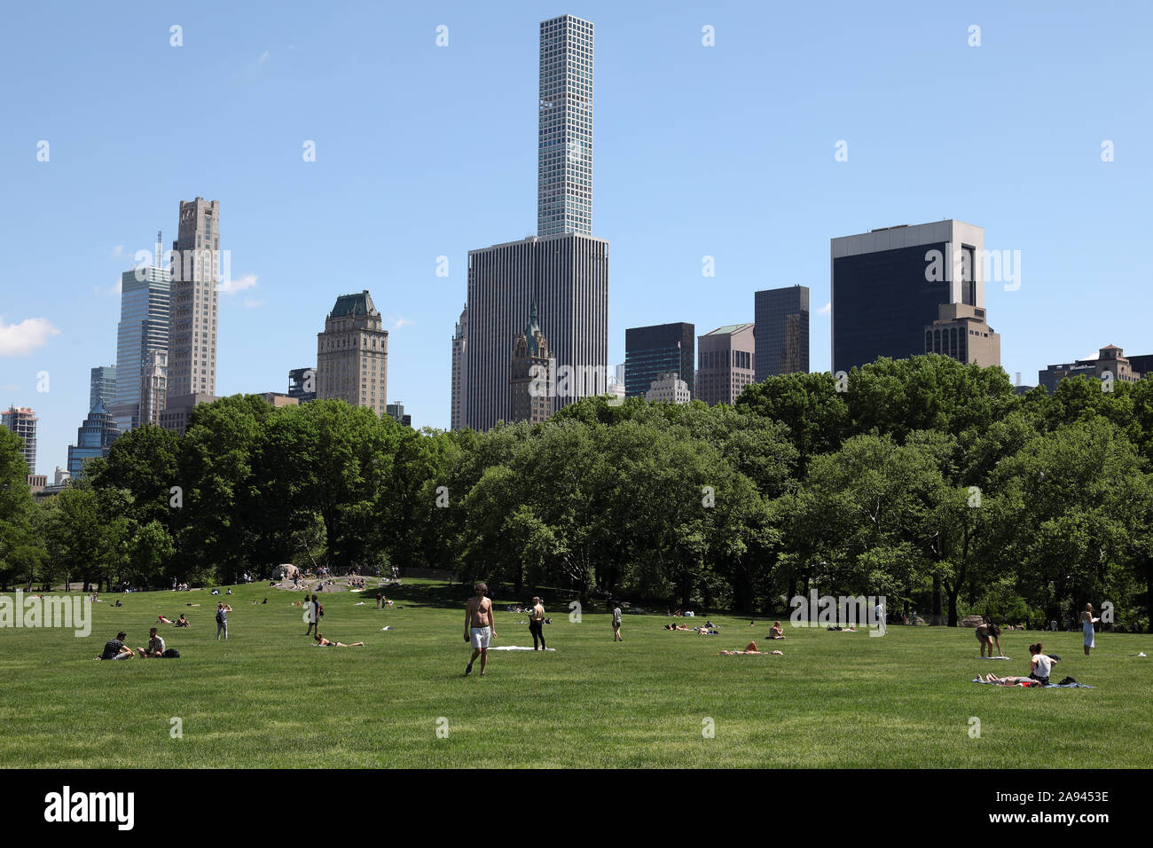 Menschen auf einen sommerlichen Tag im Central Park mit Skyline Kulisse entspannen Stockfoto