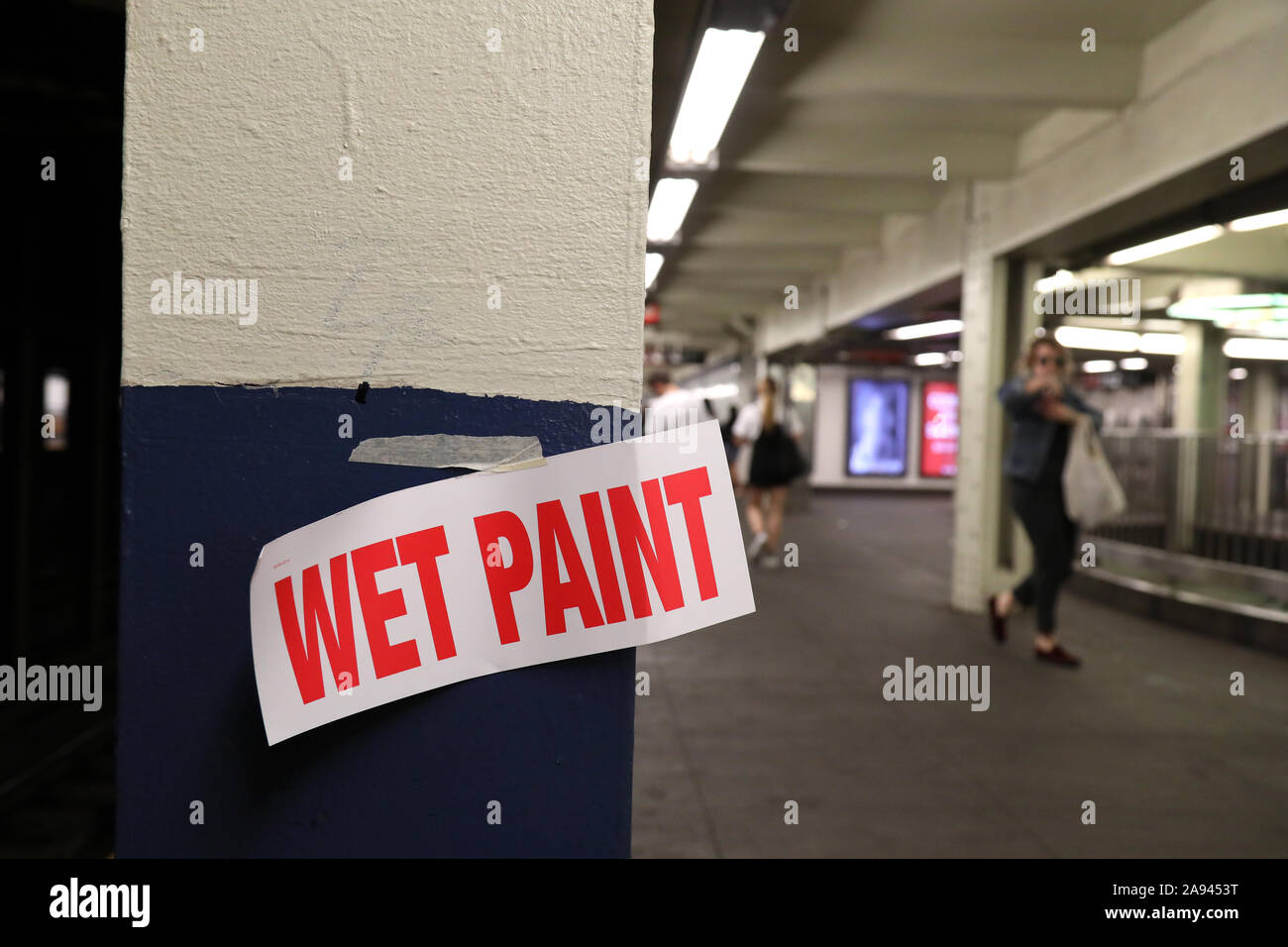 Einen nassen Lack Schild geklebt eine Plattform Spalte in einer New Yorker U-Bahn. Stockfoto