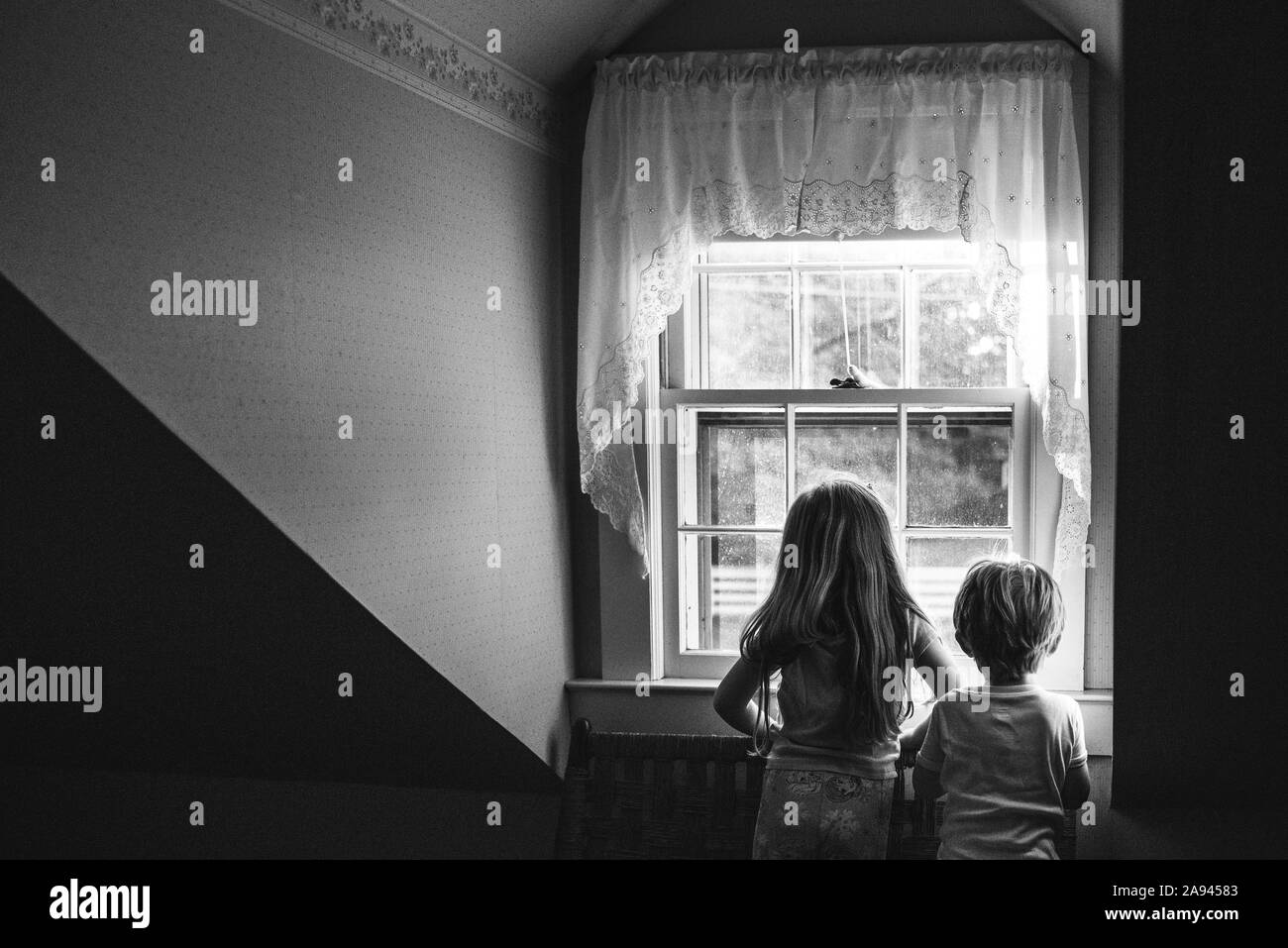 Zwei Kinder Blick aus dem Fenster. Stockfoto